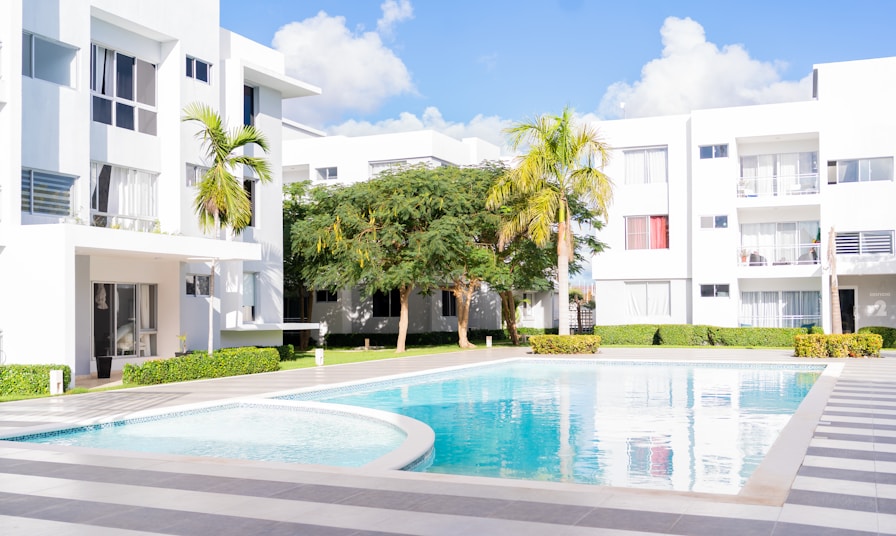 A swimming pool in front of a white building