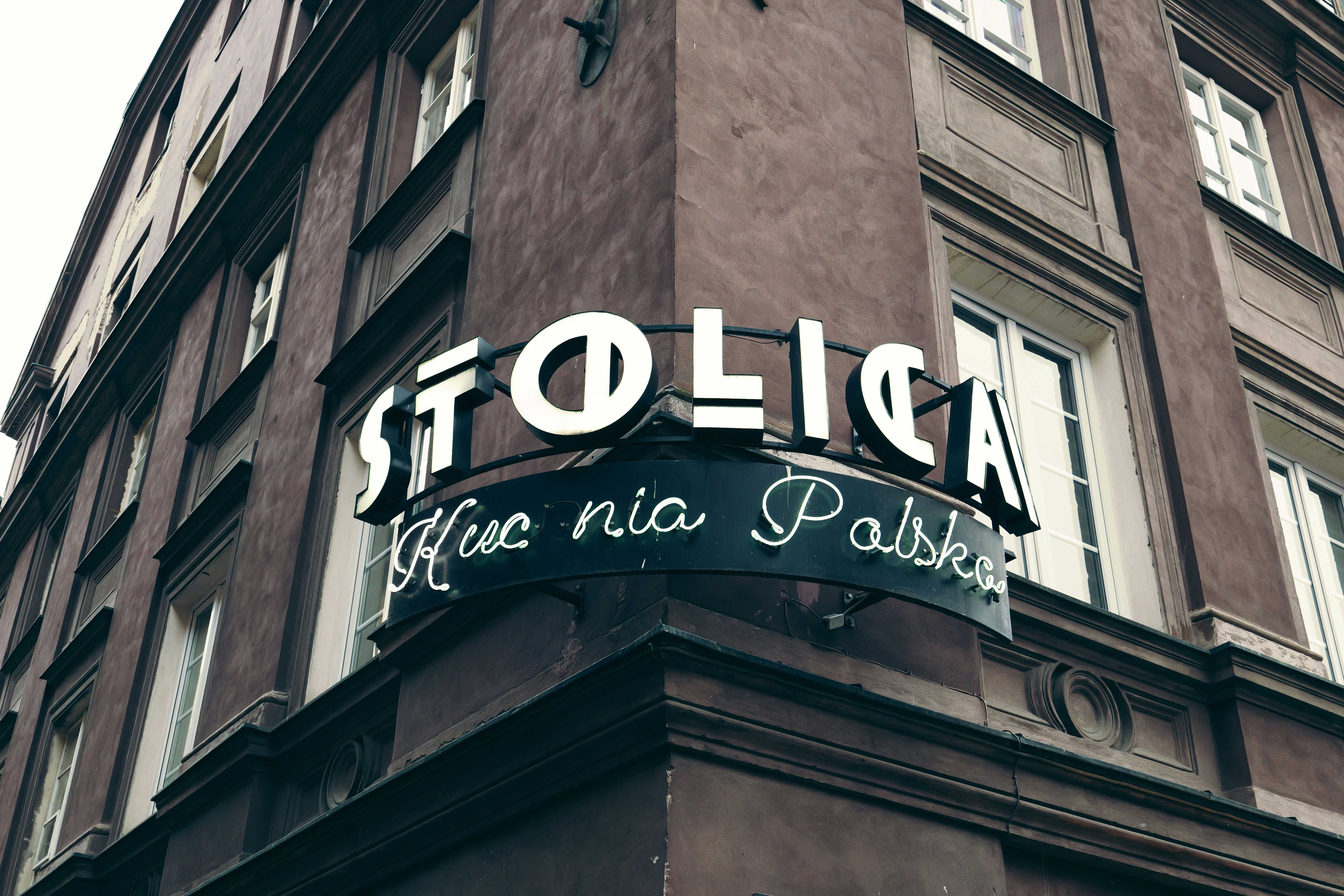 A tall brown building with a sign on the side of it