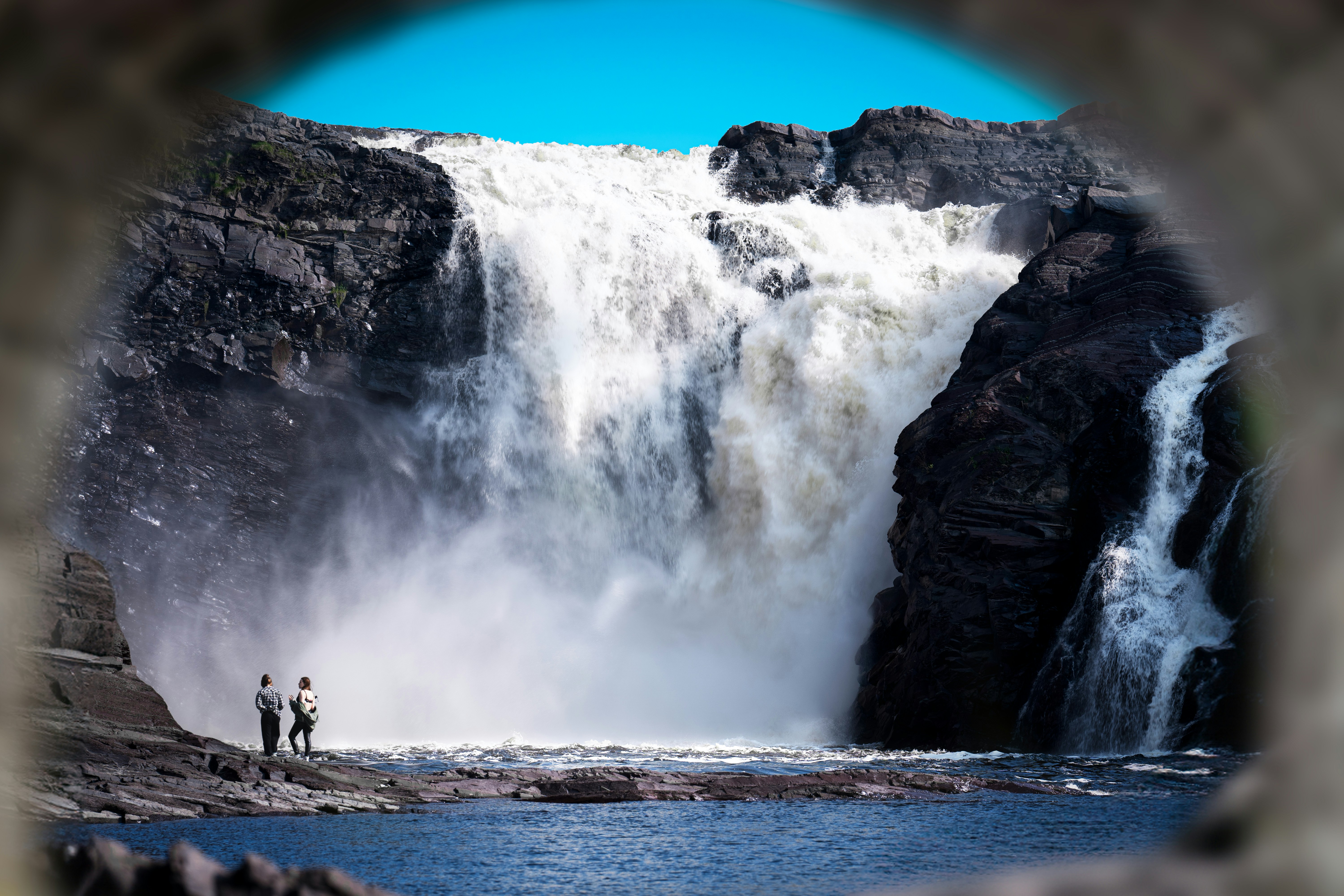 A man standing in front of a waterfall
