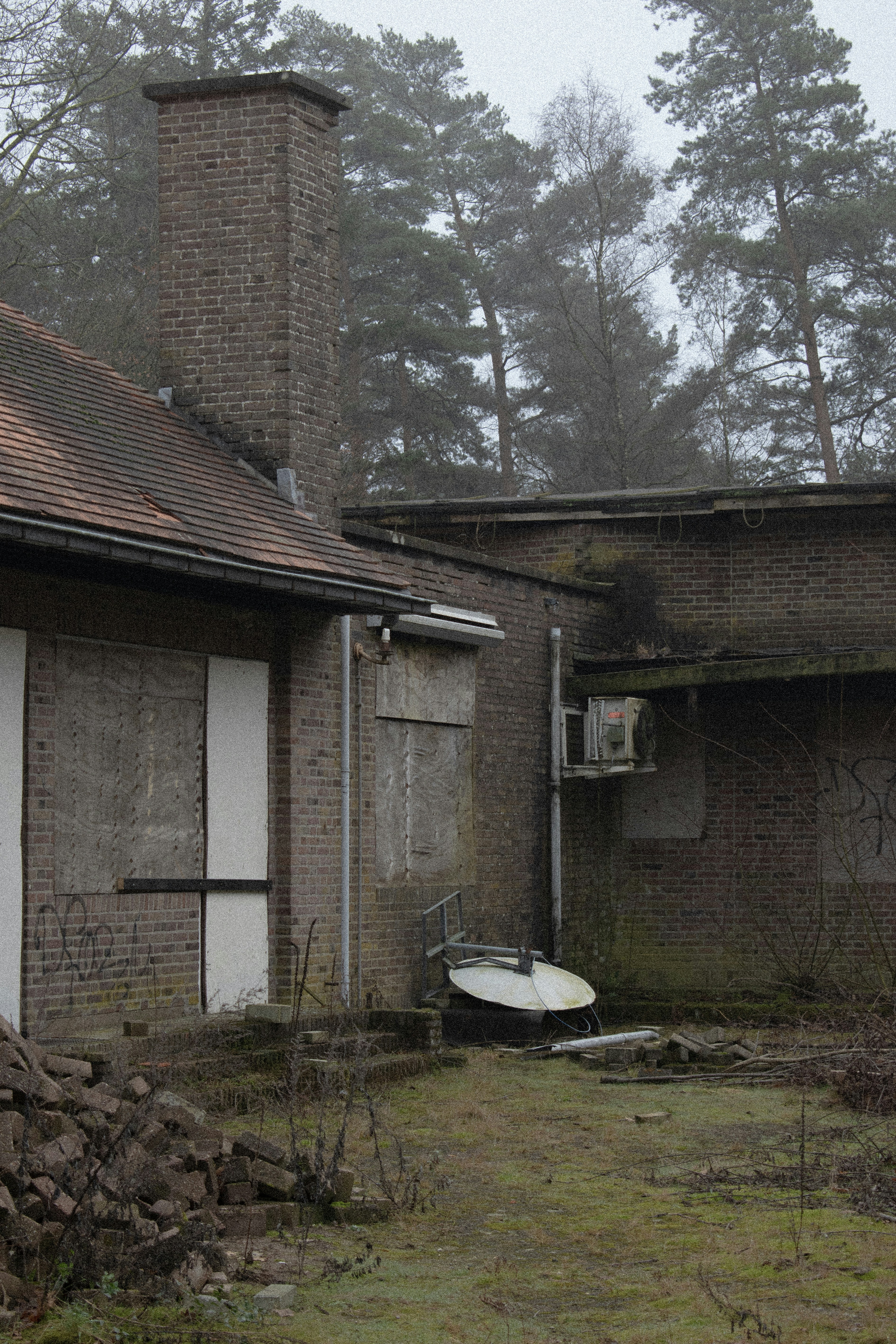 An old brick building with a boat in the yard