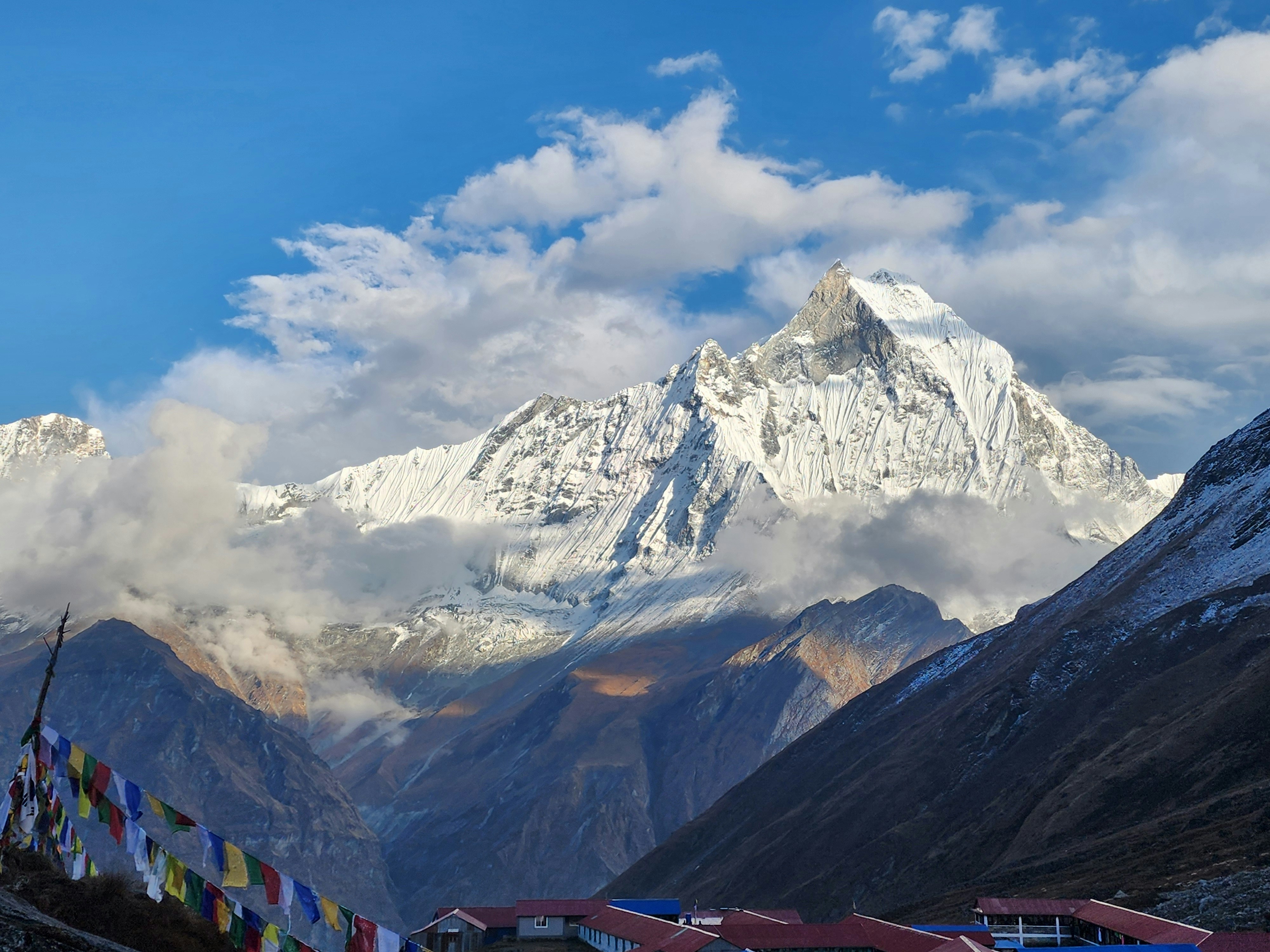 A view of a mountain range with prayer flags in the foreground