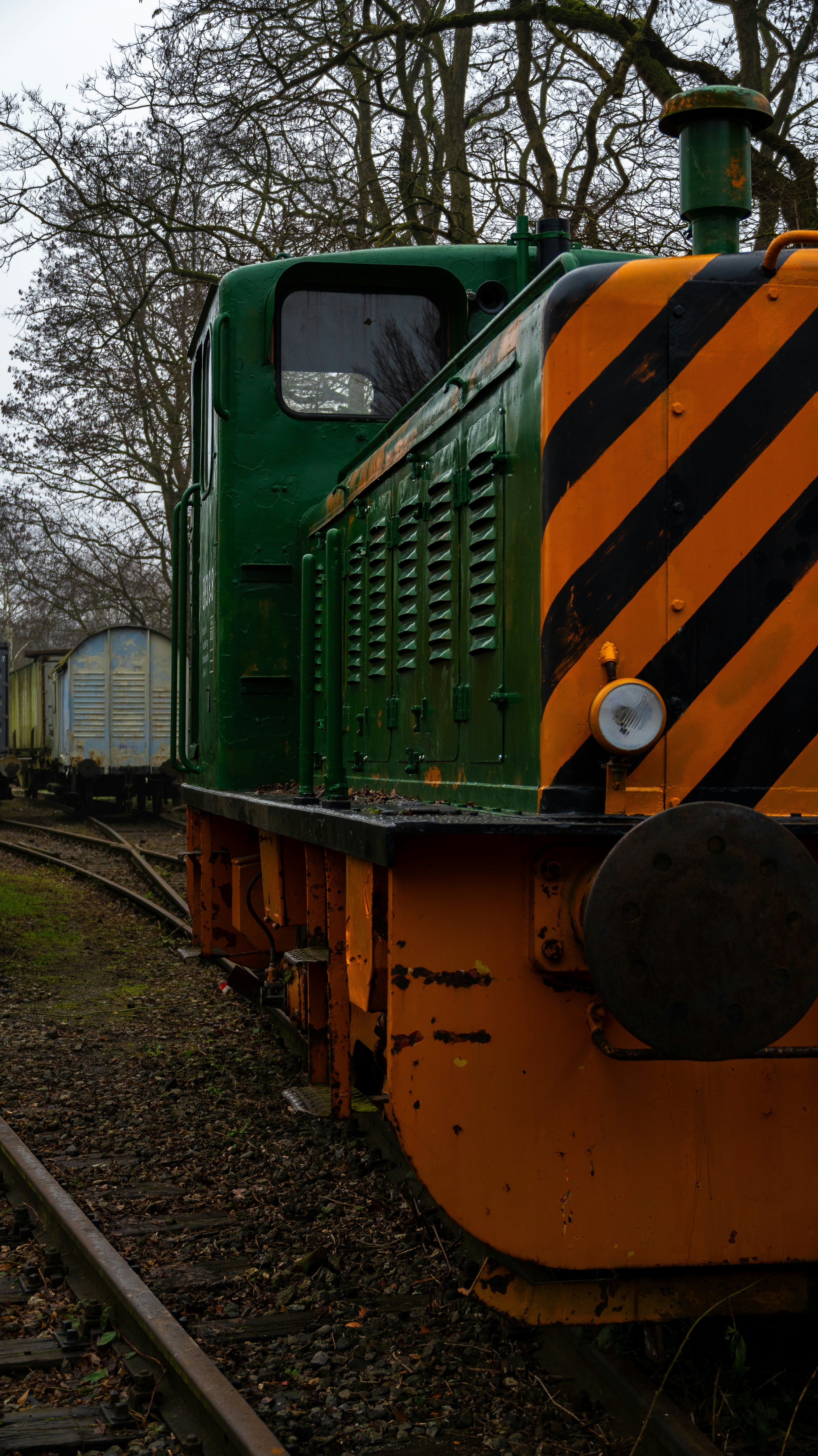 A green and yellow train traveling down train tracks