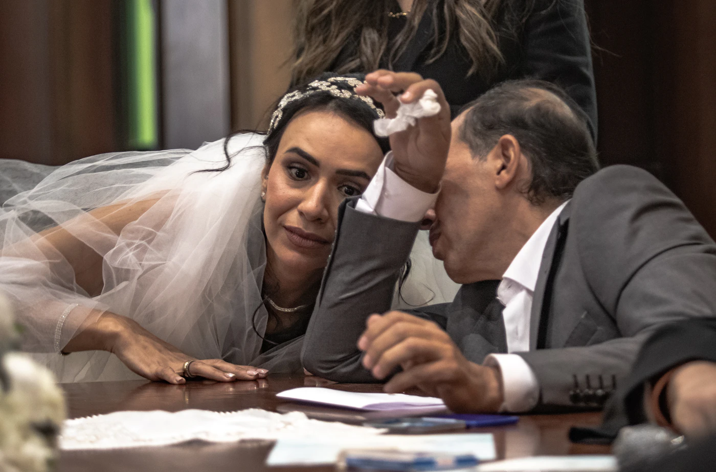 Wedding vendor tipping etiquette explained — A bride thanks her wedding planner and catering staff at the reception.