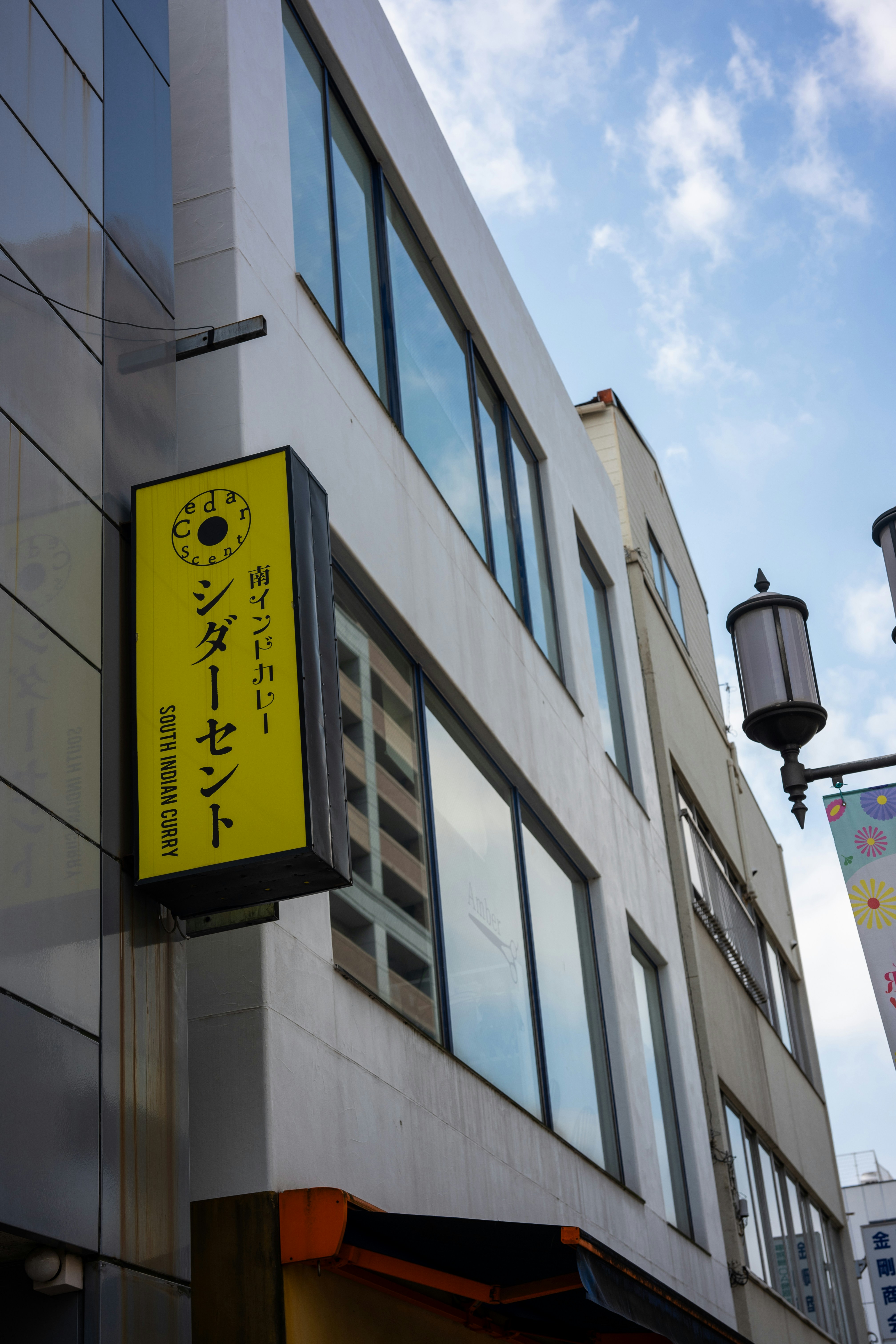 A building with a yellow sign hanging off the side of it photo – Free ...