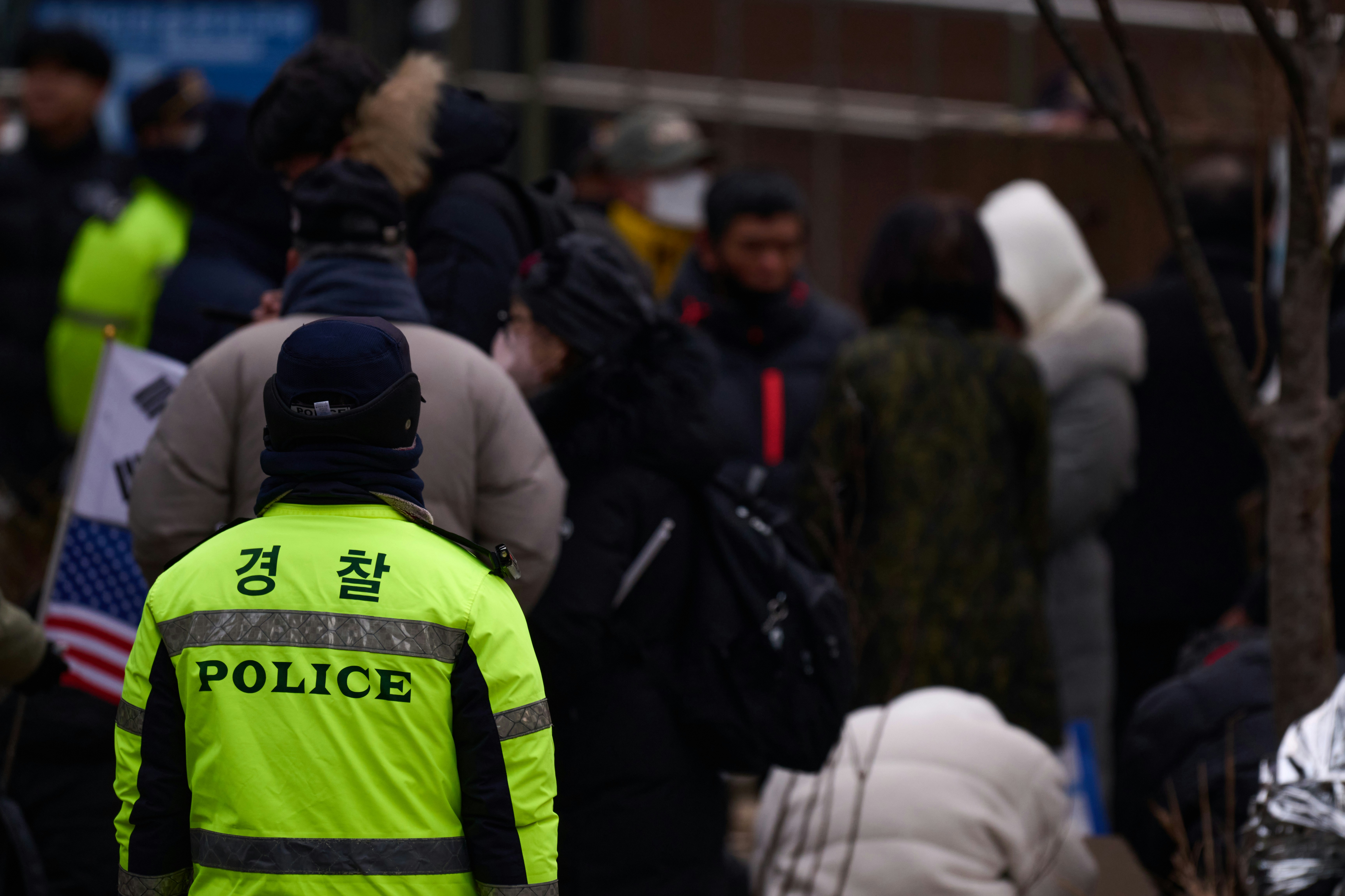 A police officer is standing in front of a crowd of people