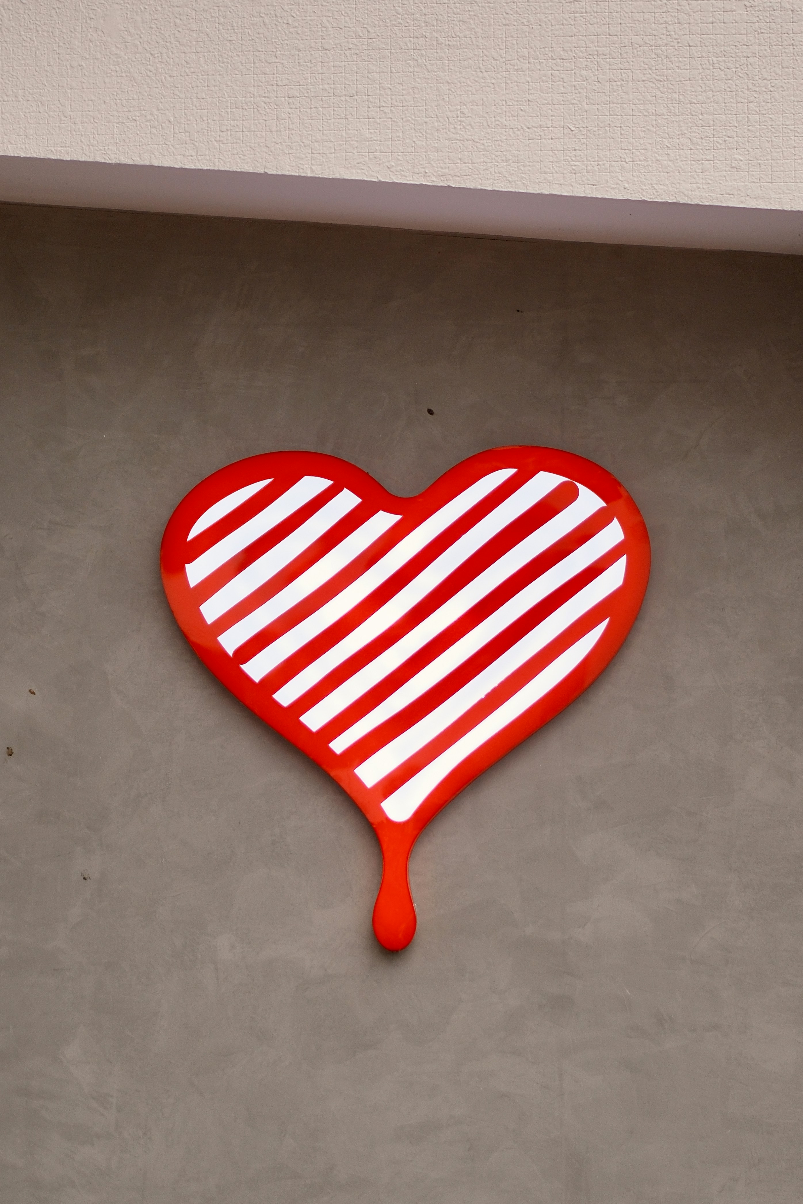 A red and white heart hanging on a wall