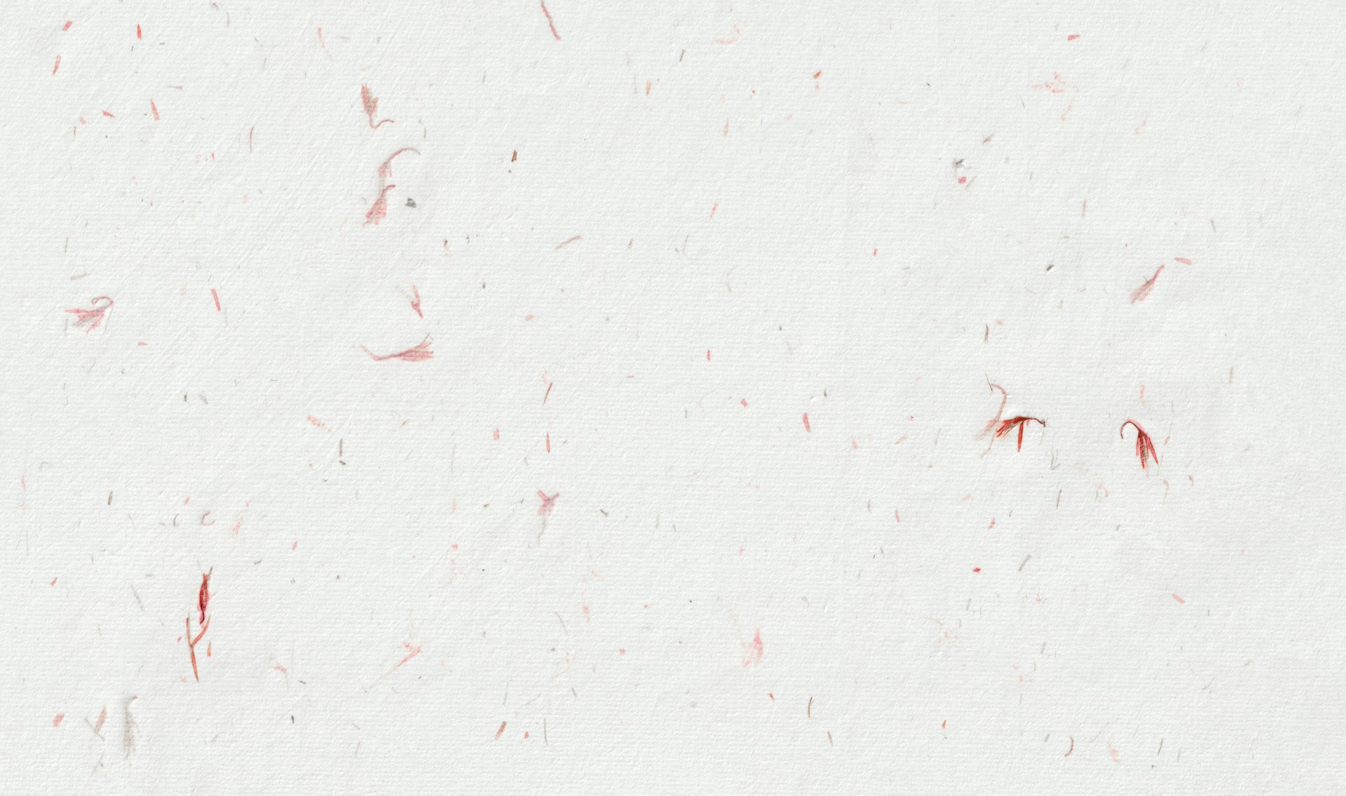 White textured background with scattered red fibers