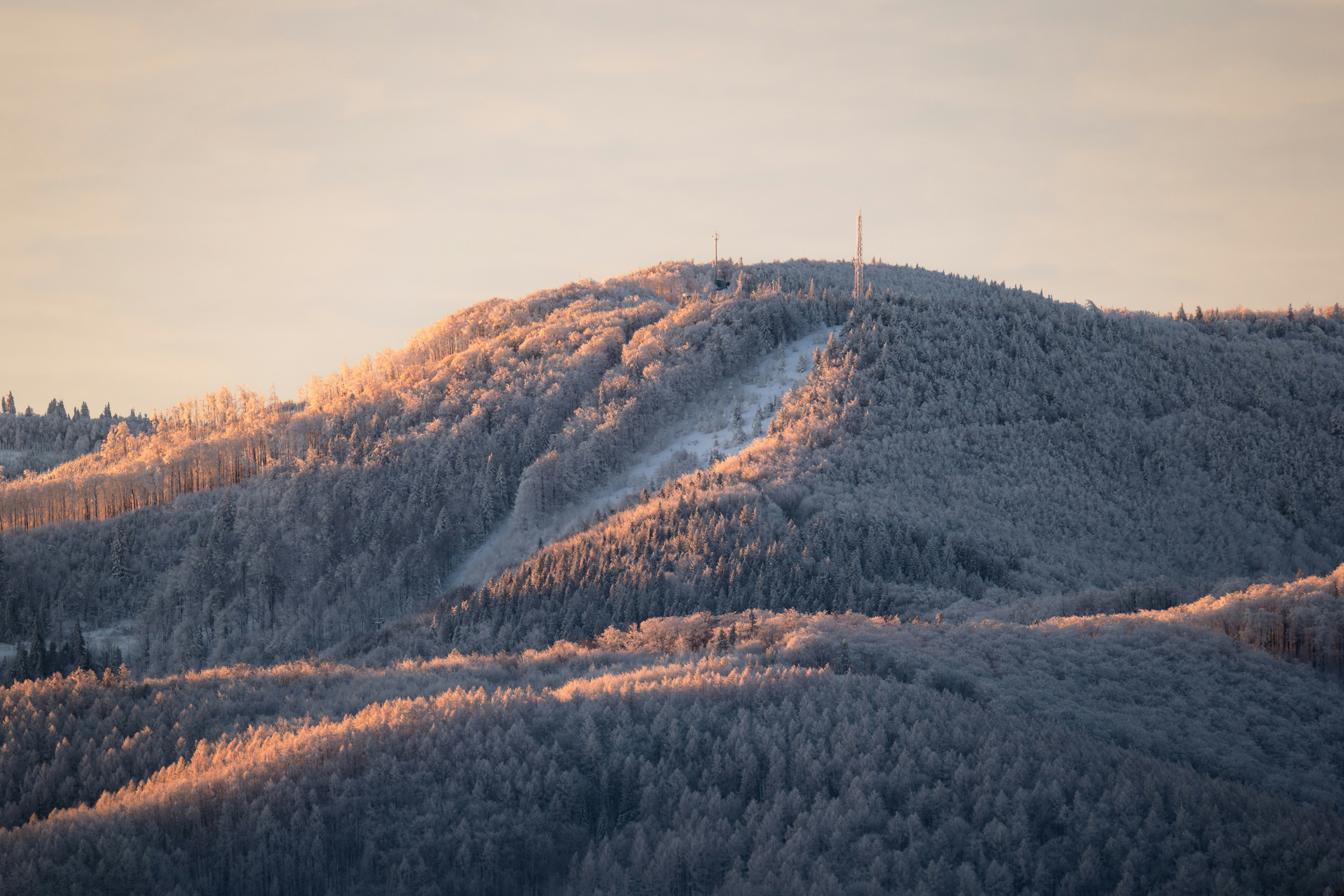 A mountain covered in snow with a ski lift in the distance
