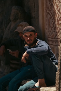 A group of men sitting on the side of a building