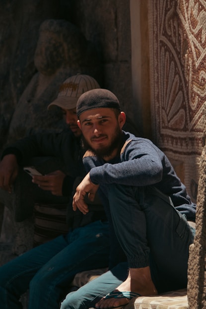 A group of men sitting on the side of a building