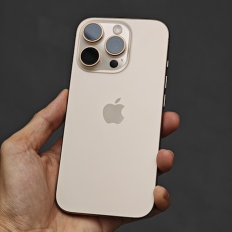 A person holding a white iPhone in their hand