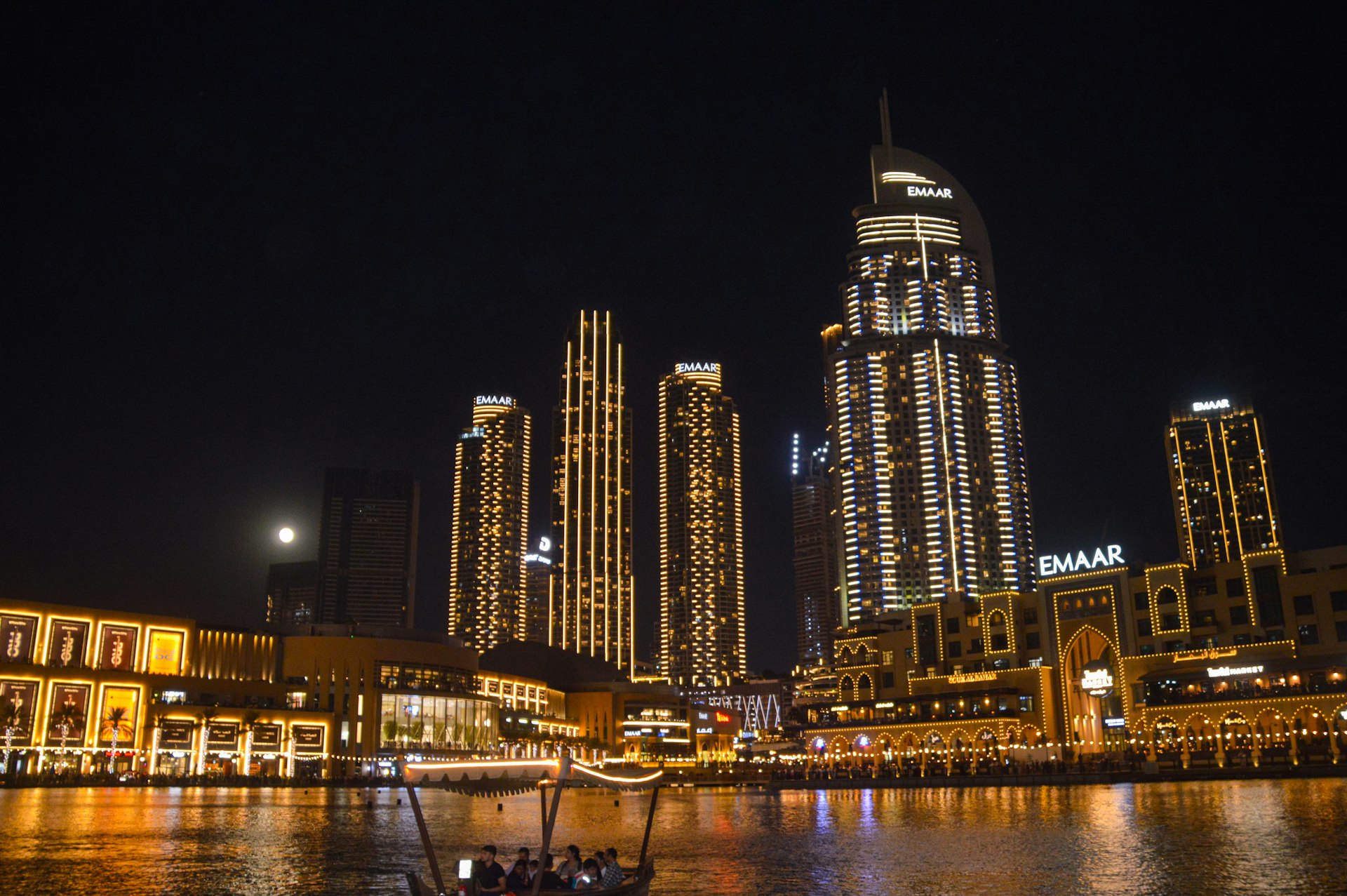 A boat floating on top of a river next to tall buildings