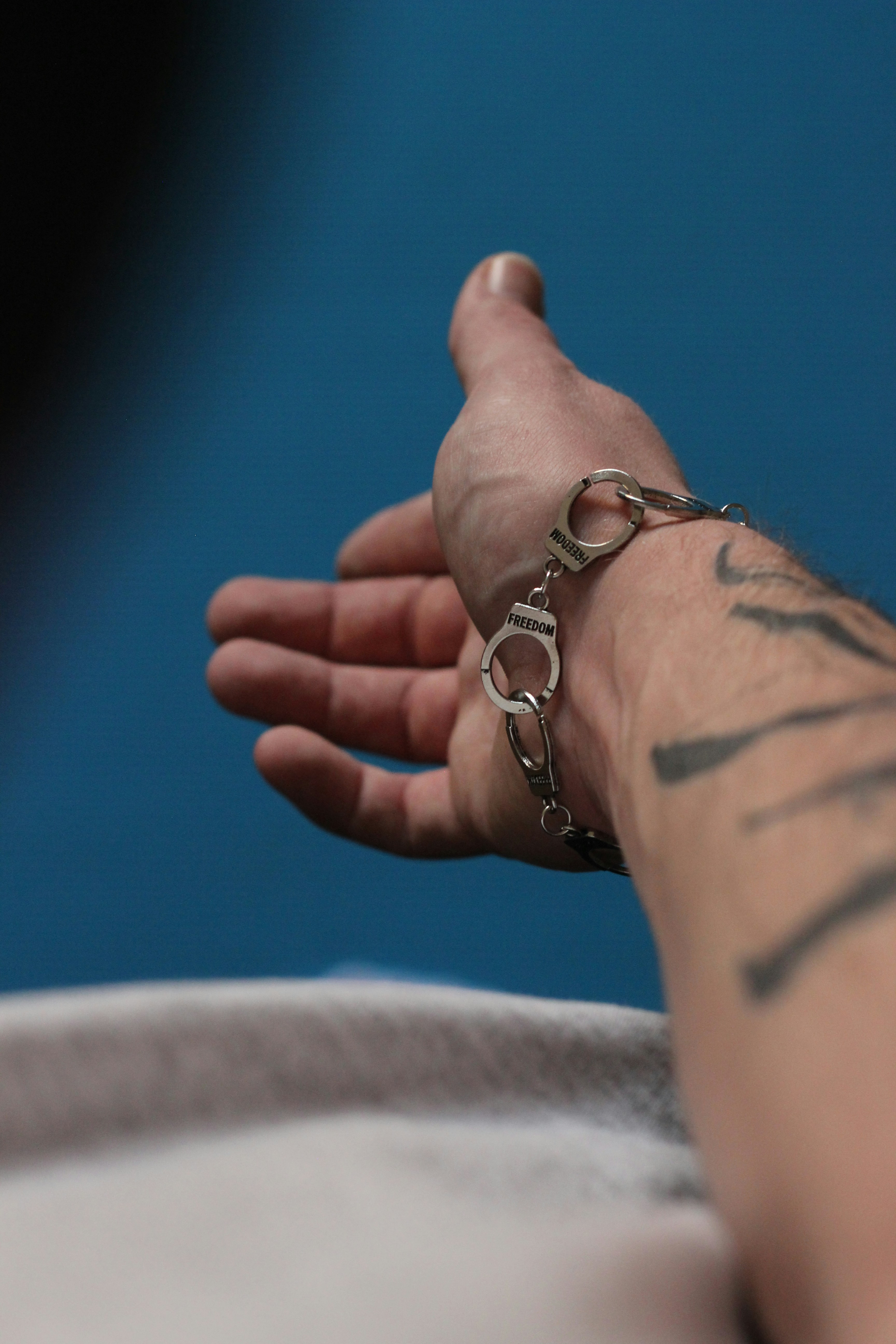 A person with a tattoo on their arm holding onto a chain