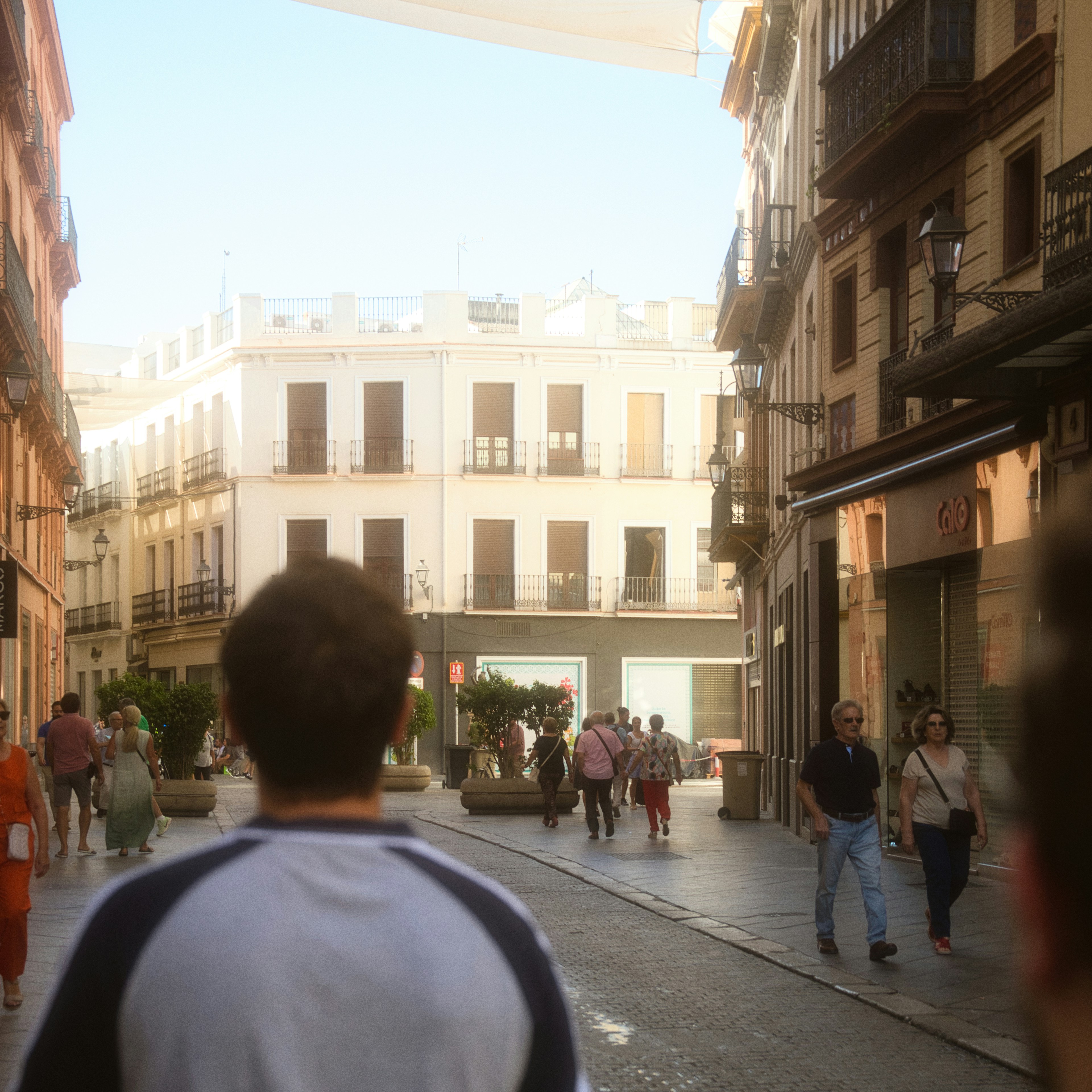 Un groupe de personnes marchant dans une rue à côté de grands immeubles
