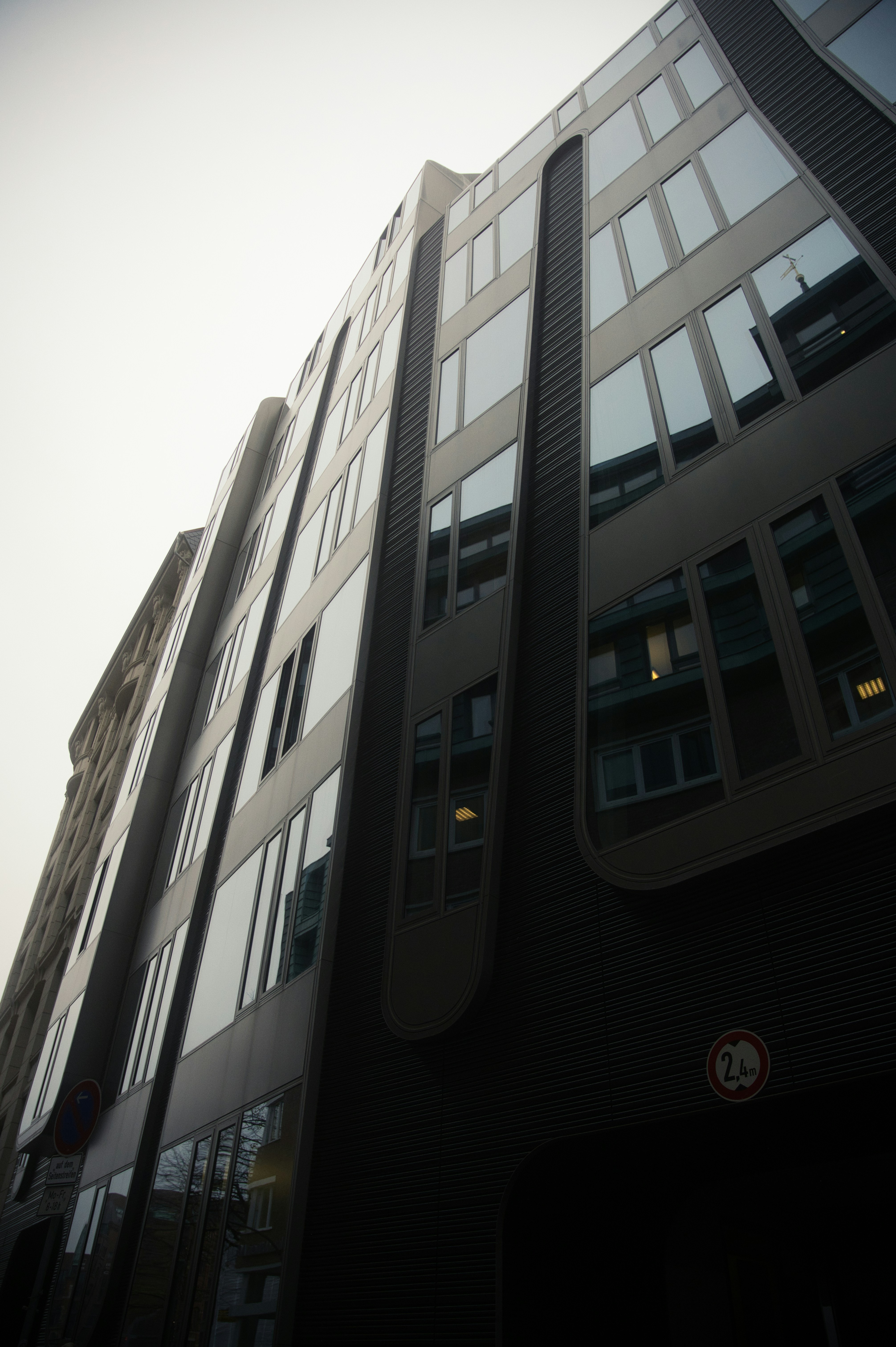 Un grand immeuble avec beaucoup de fenêtres à côté d’une rue