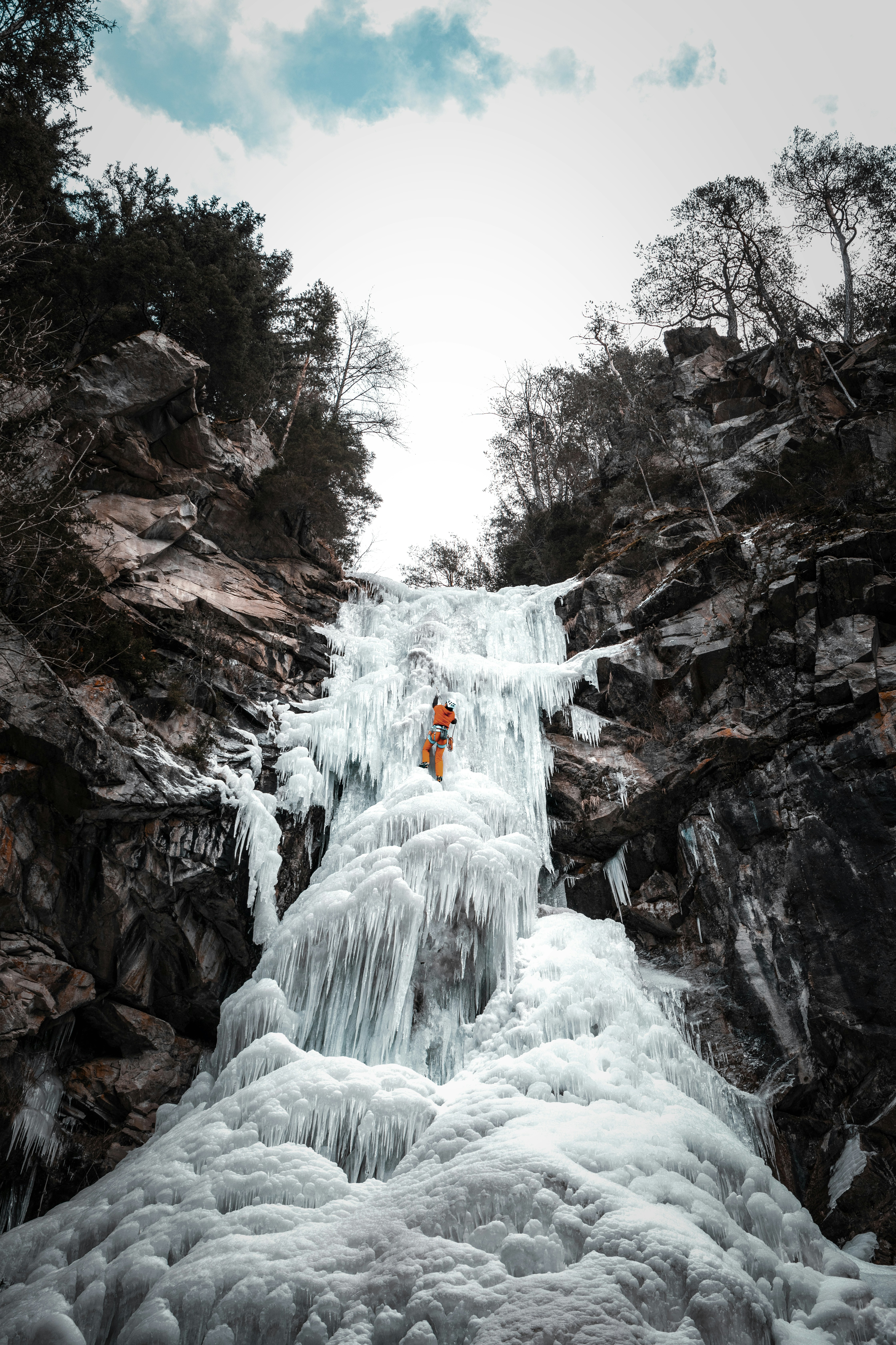A man standing on top of a frozen waterfall