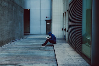 A person sitting on the ground in a hallway