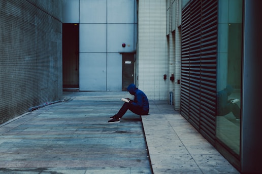 A person sitting on the ground in a hallway