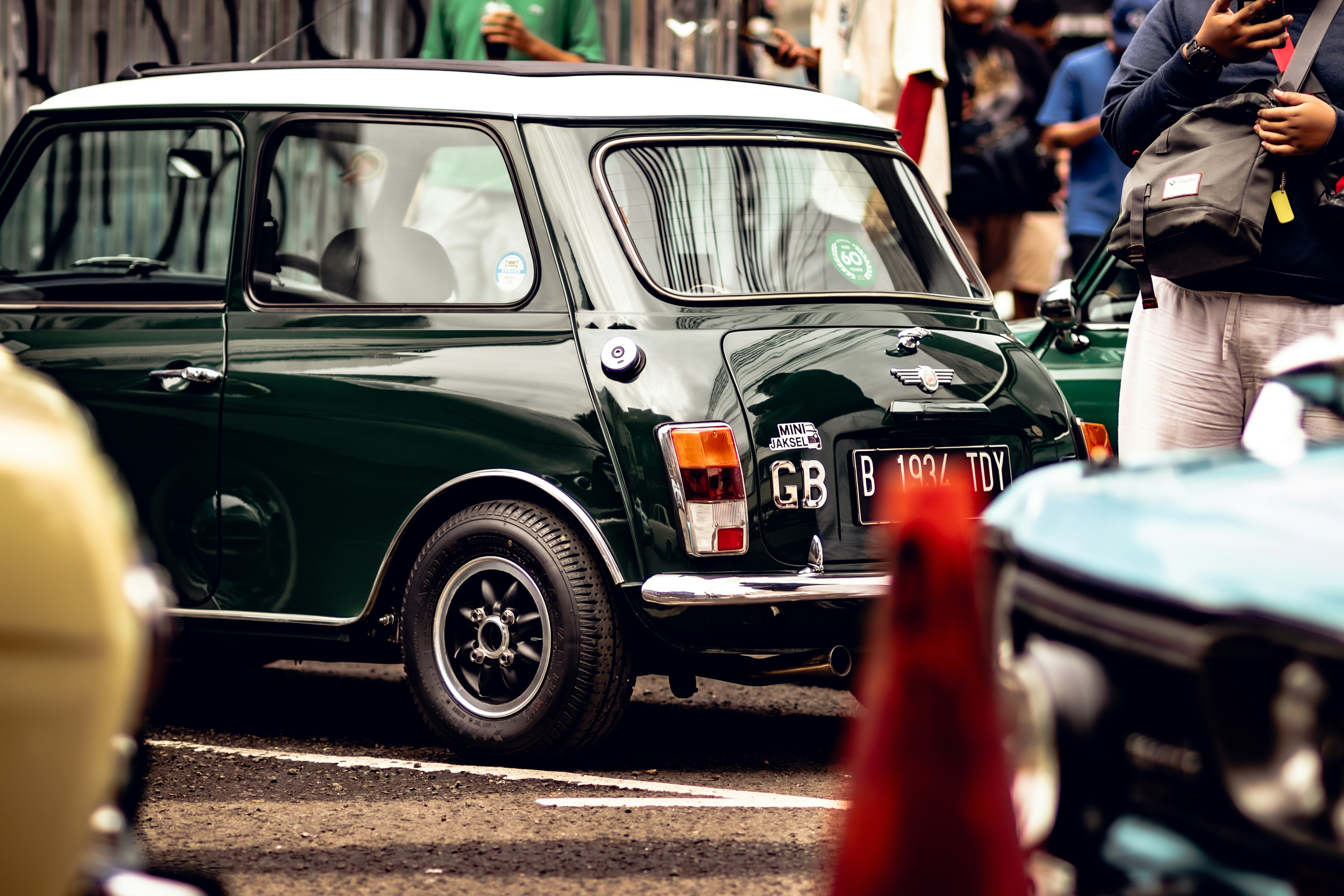 A small green car parked in a parking lot