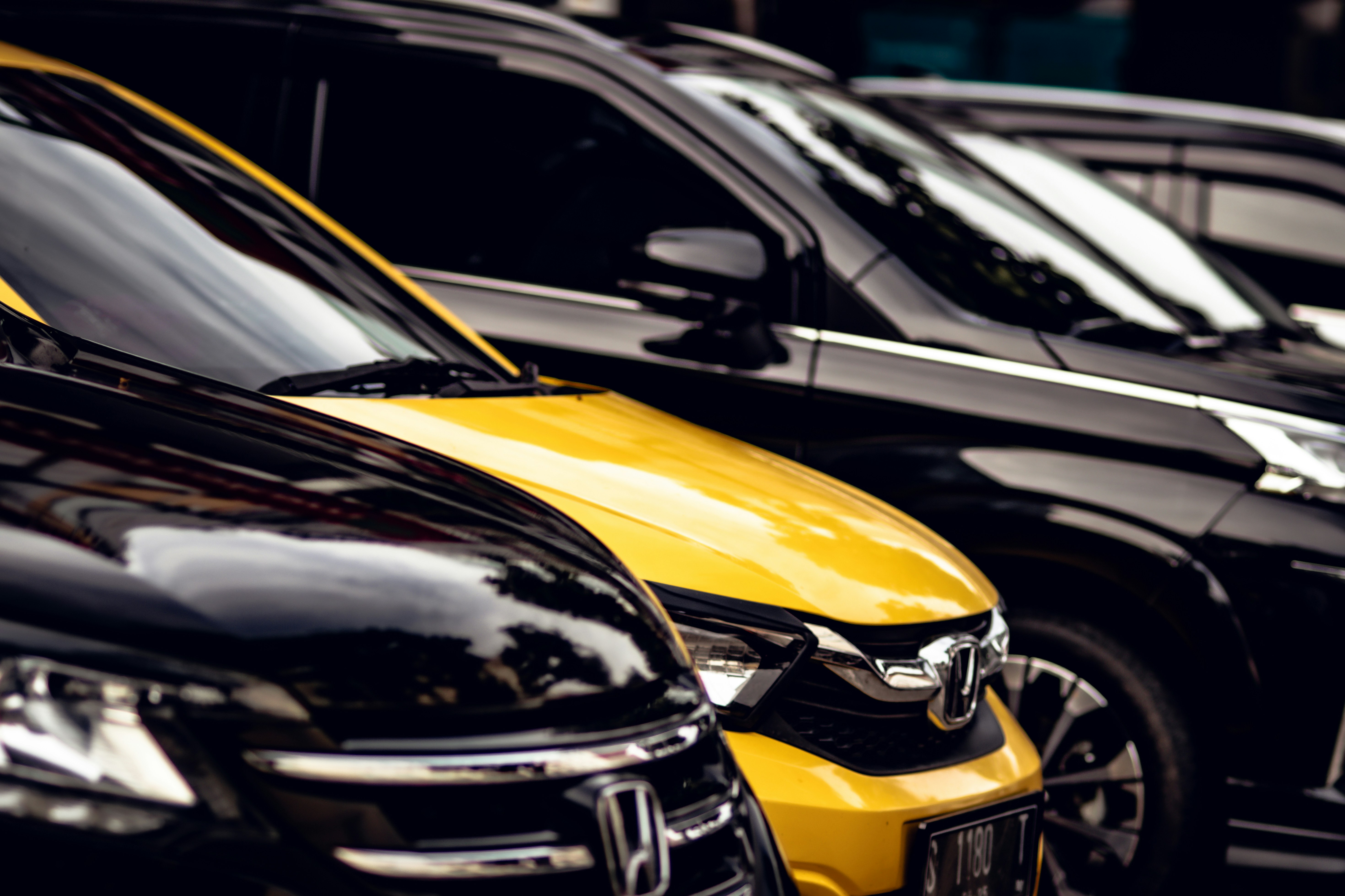 A row of parked cars sitting next to each other