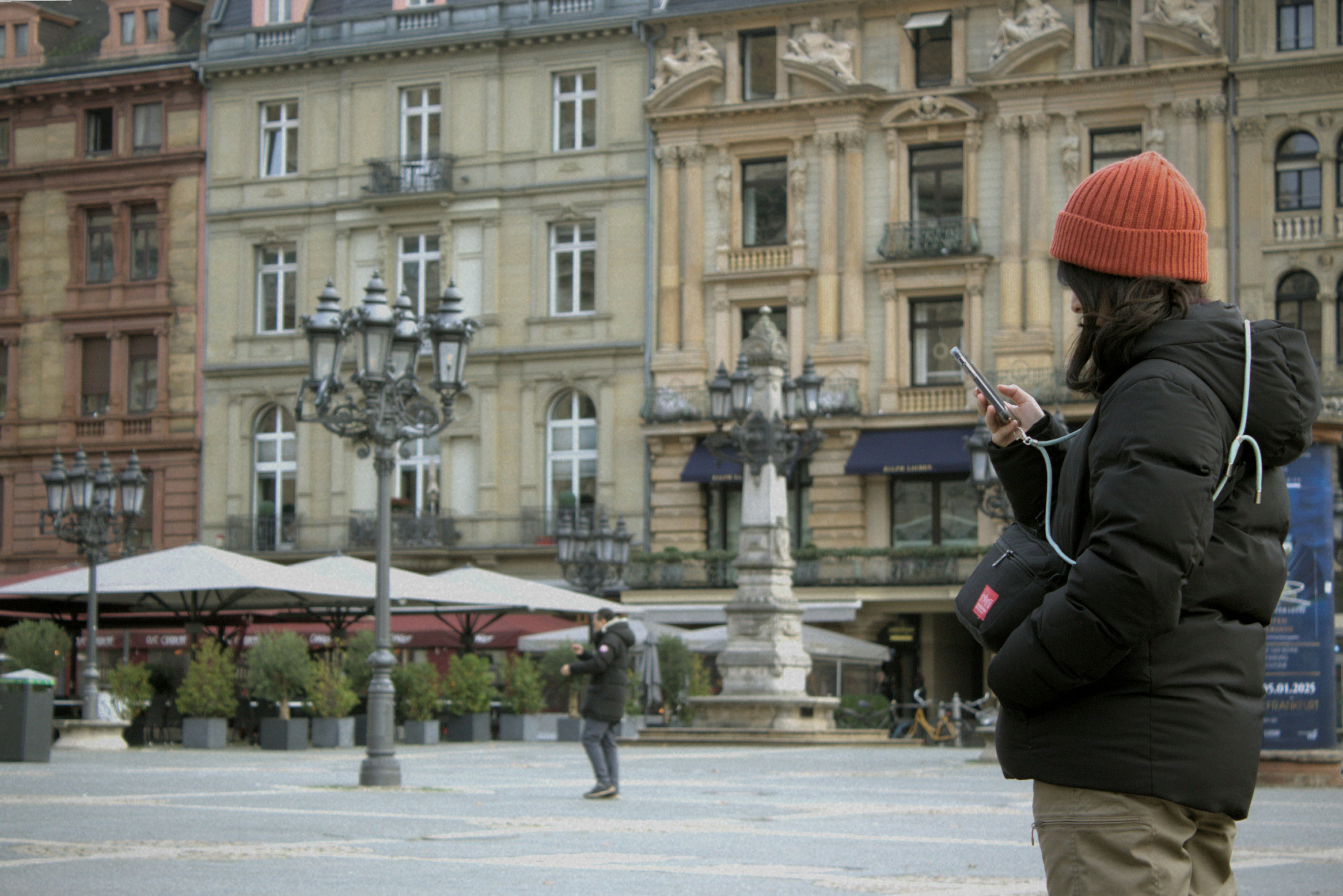 A person in a red hat looking at a cell phone