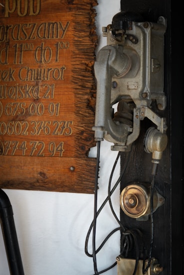 An old fashioned telephone is hanging on a wall