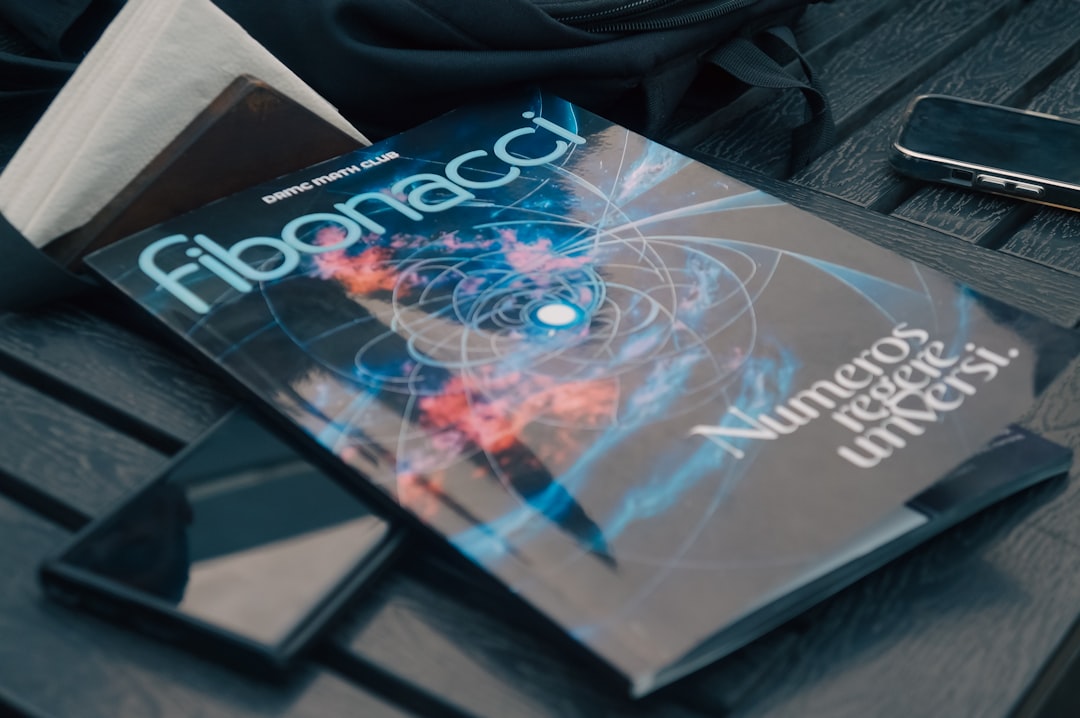 A book sitting on top of a wooden table, Exploring the beauty of numbers and the universe—where math meets the cosmos - Fibonacci magazine from DRMC Math Club