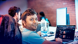 A man sitting in front of a laptop computer