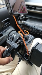 A person holding a camera in a car