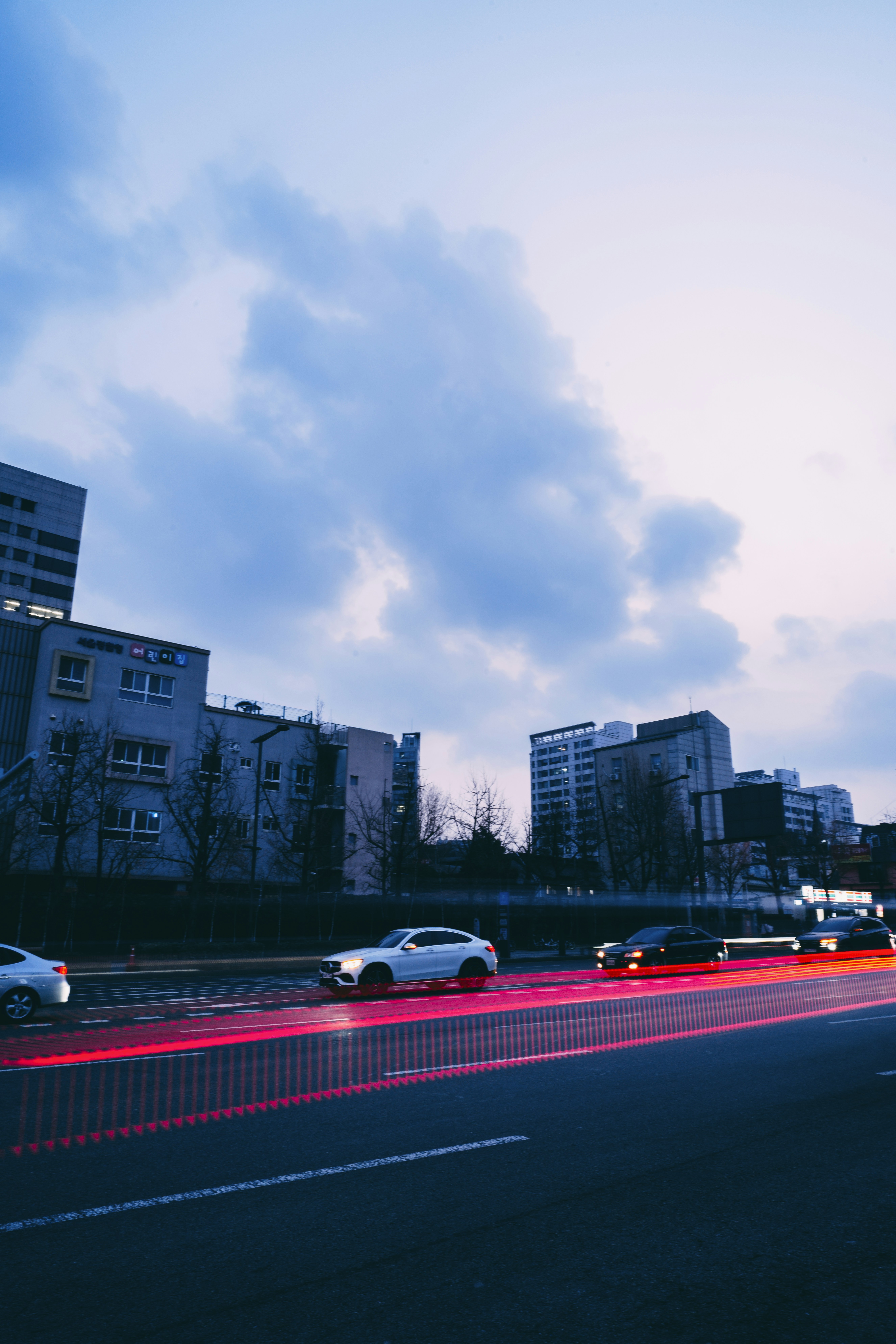 A street filled with lots of traffic next to tall buildings