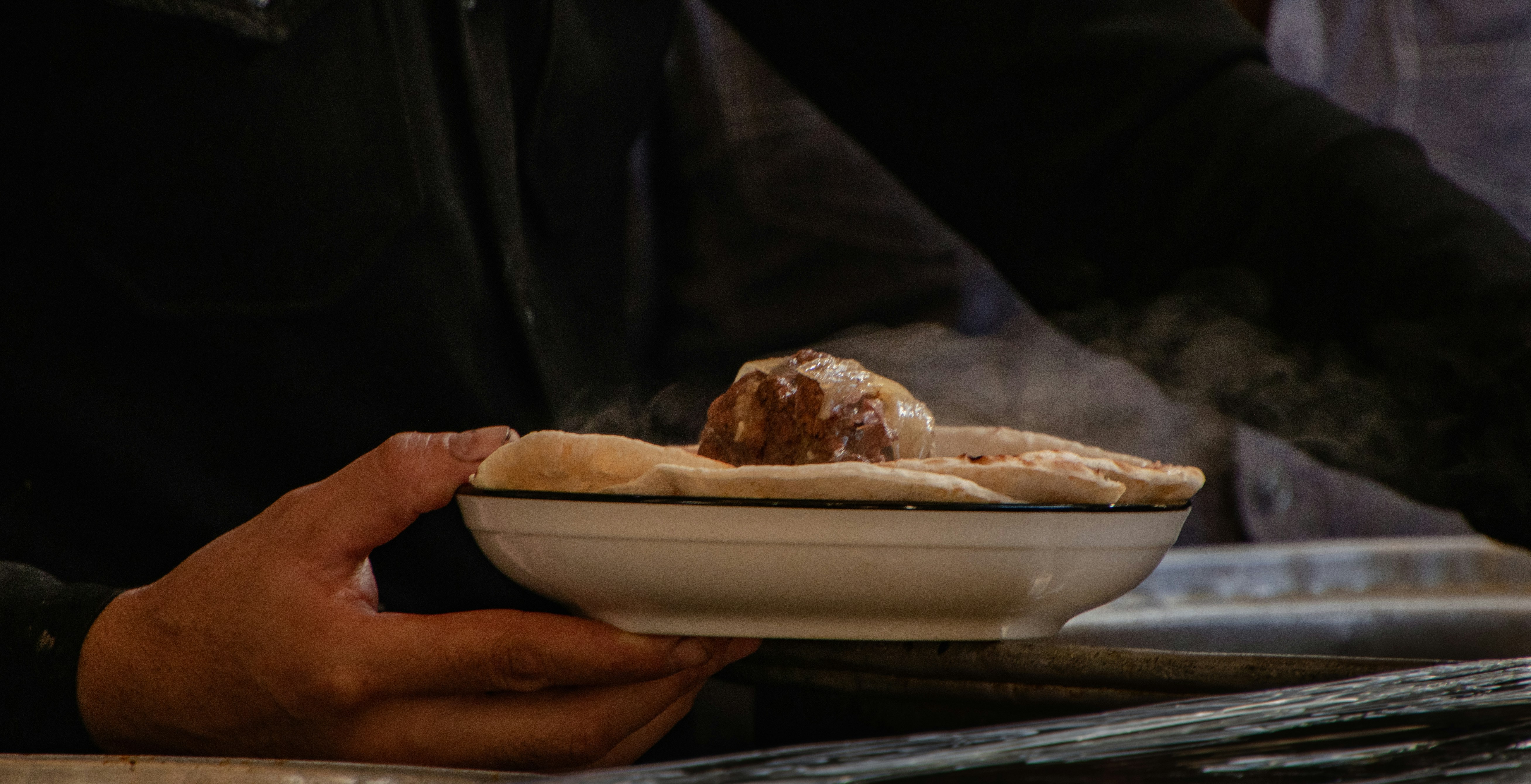 A person is holding a bowl of food