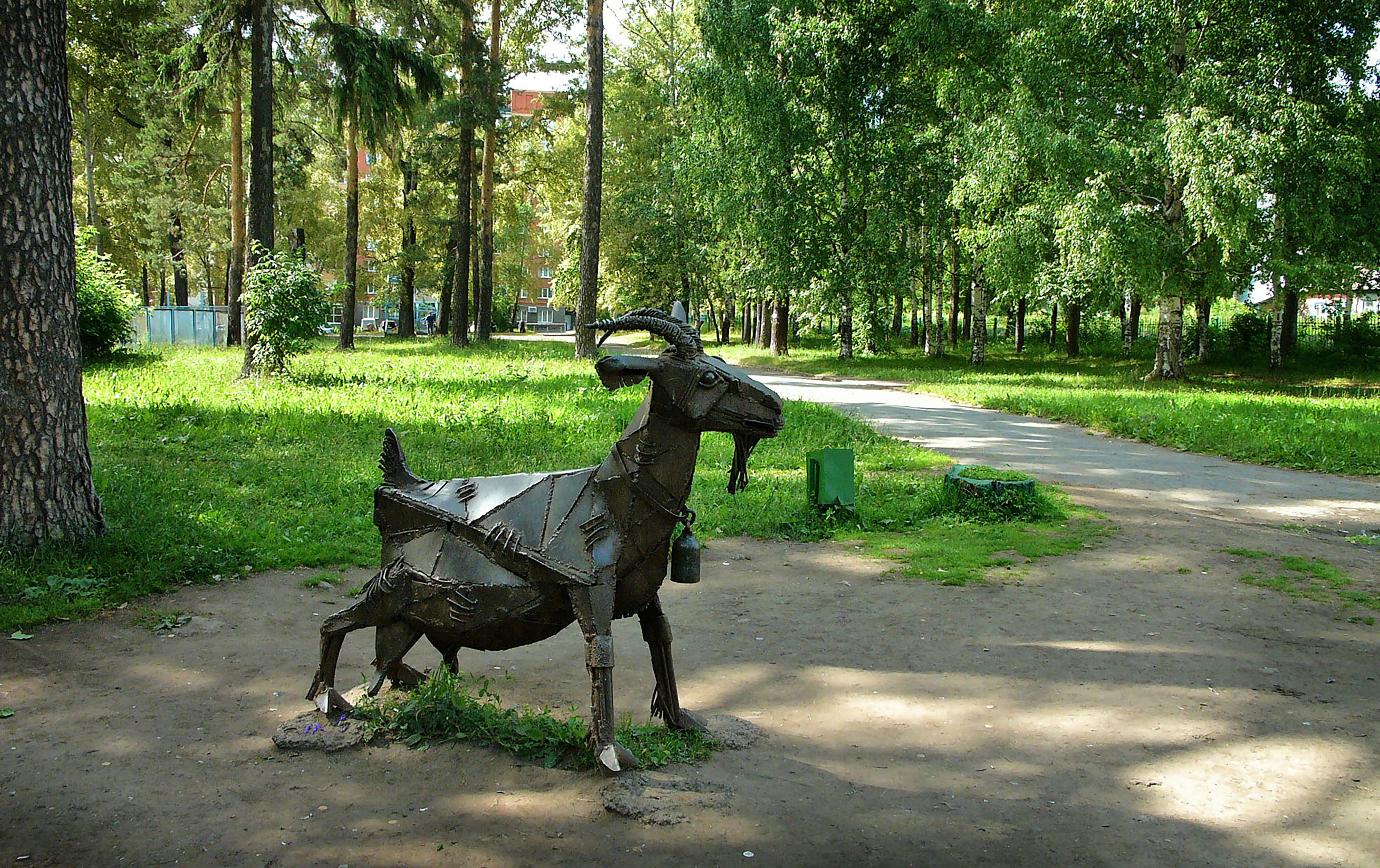 A statue of a dog in the middle of a park