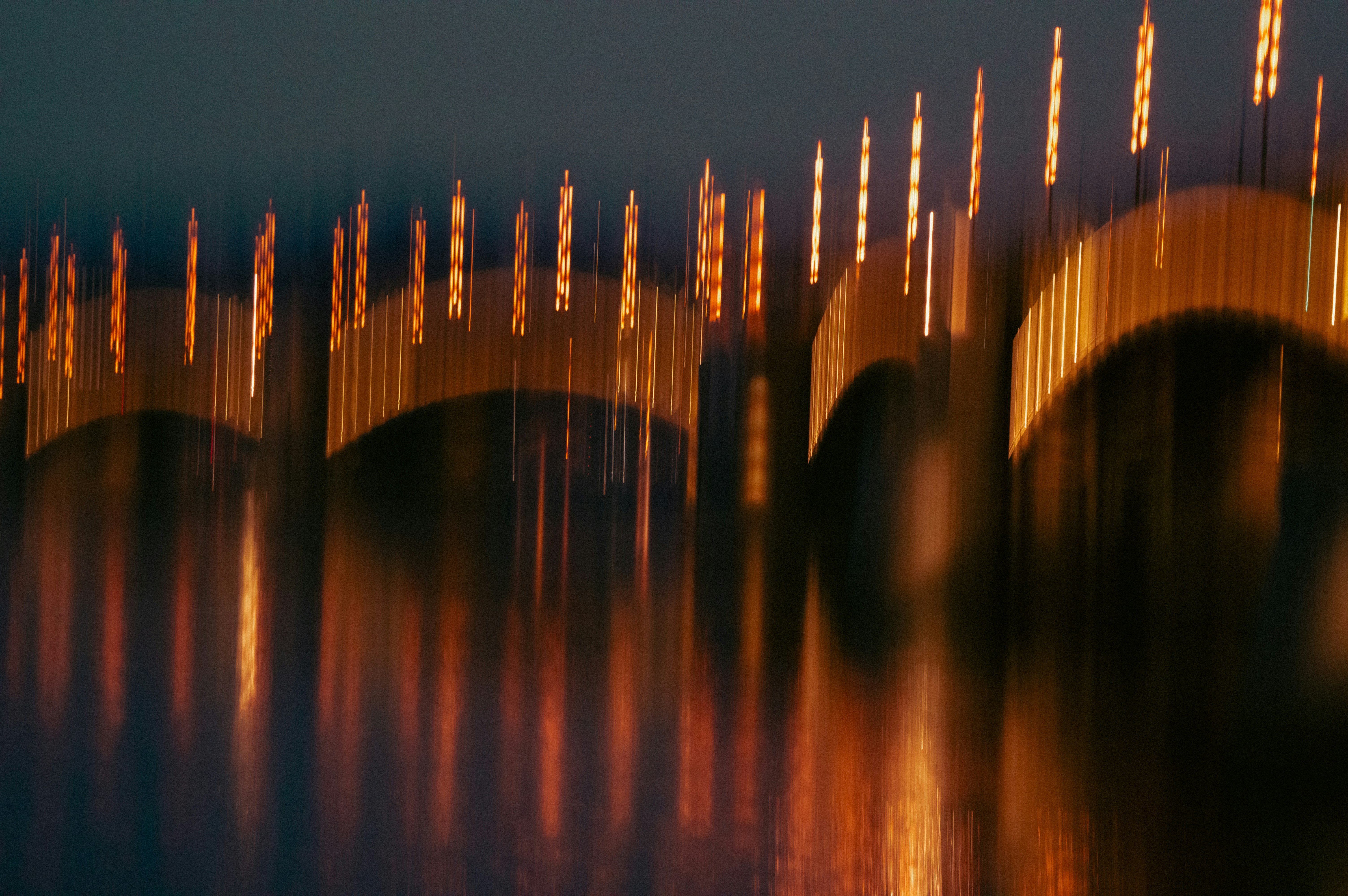 A bridge that is over some water at night