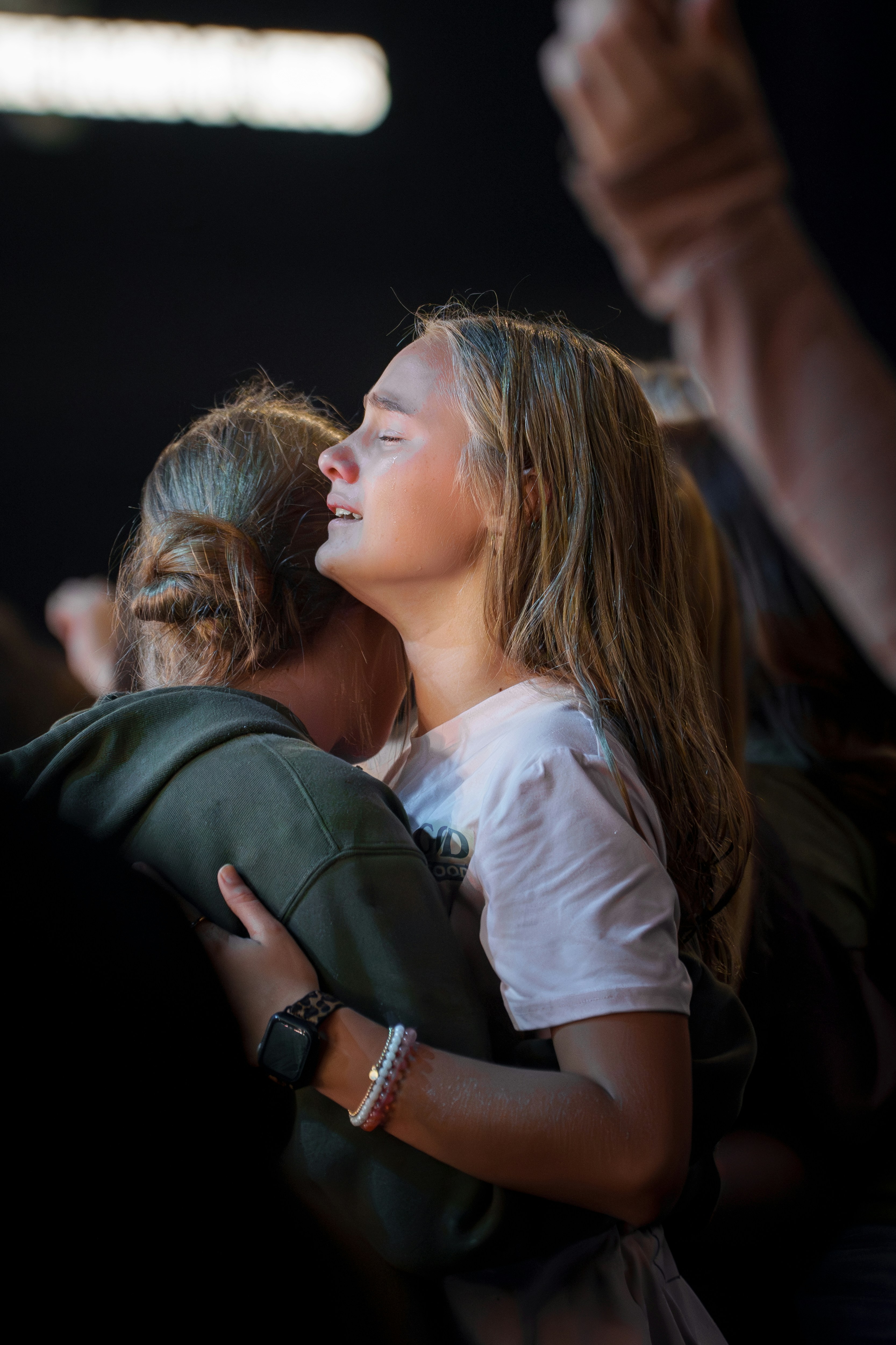A woman hugging another woman in a crowd
