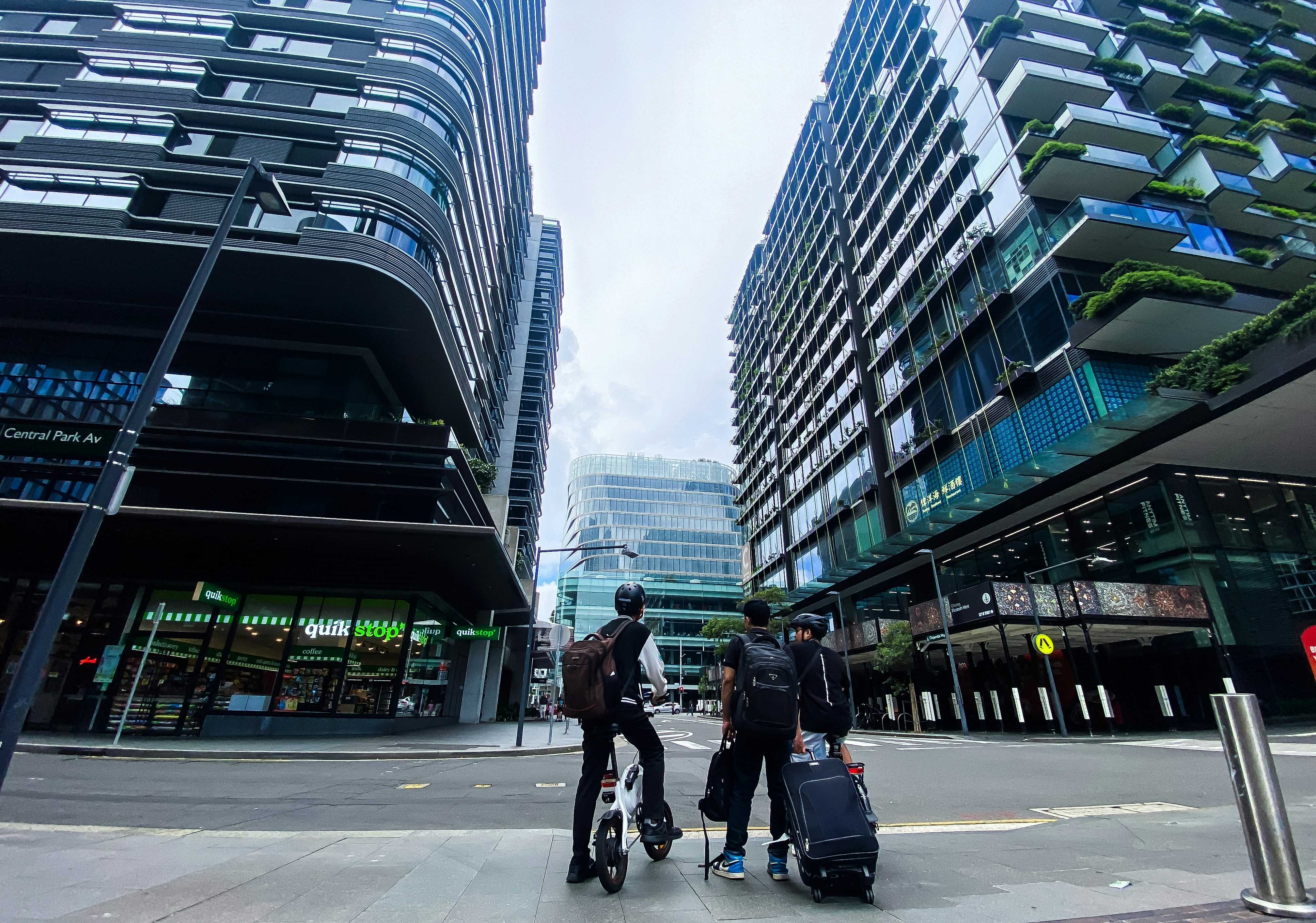 A group of people walking down a street next to tall buildings