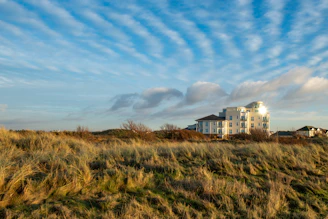 A large white building sitting on top of a lush green field