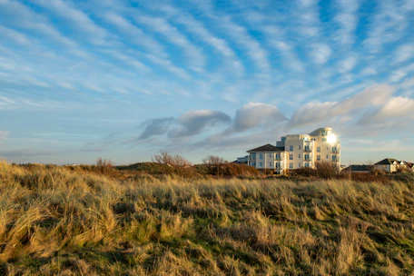 A large white building sitting on top of a lush green field