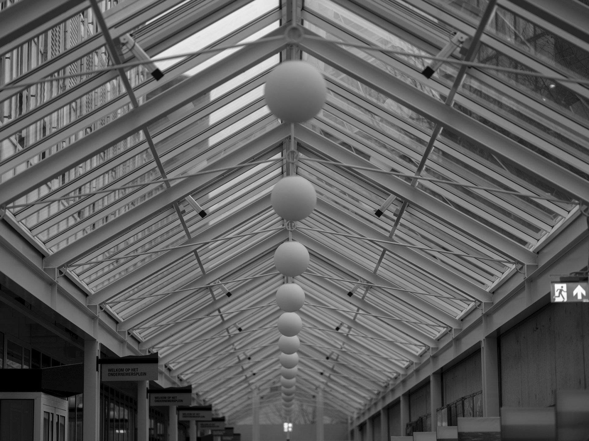 A black and white photo of a walkway in a building