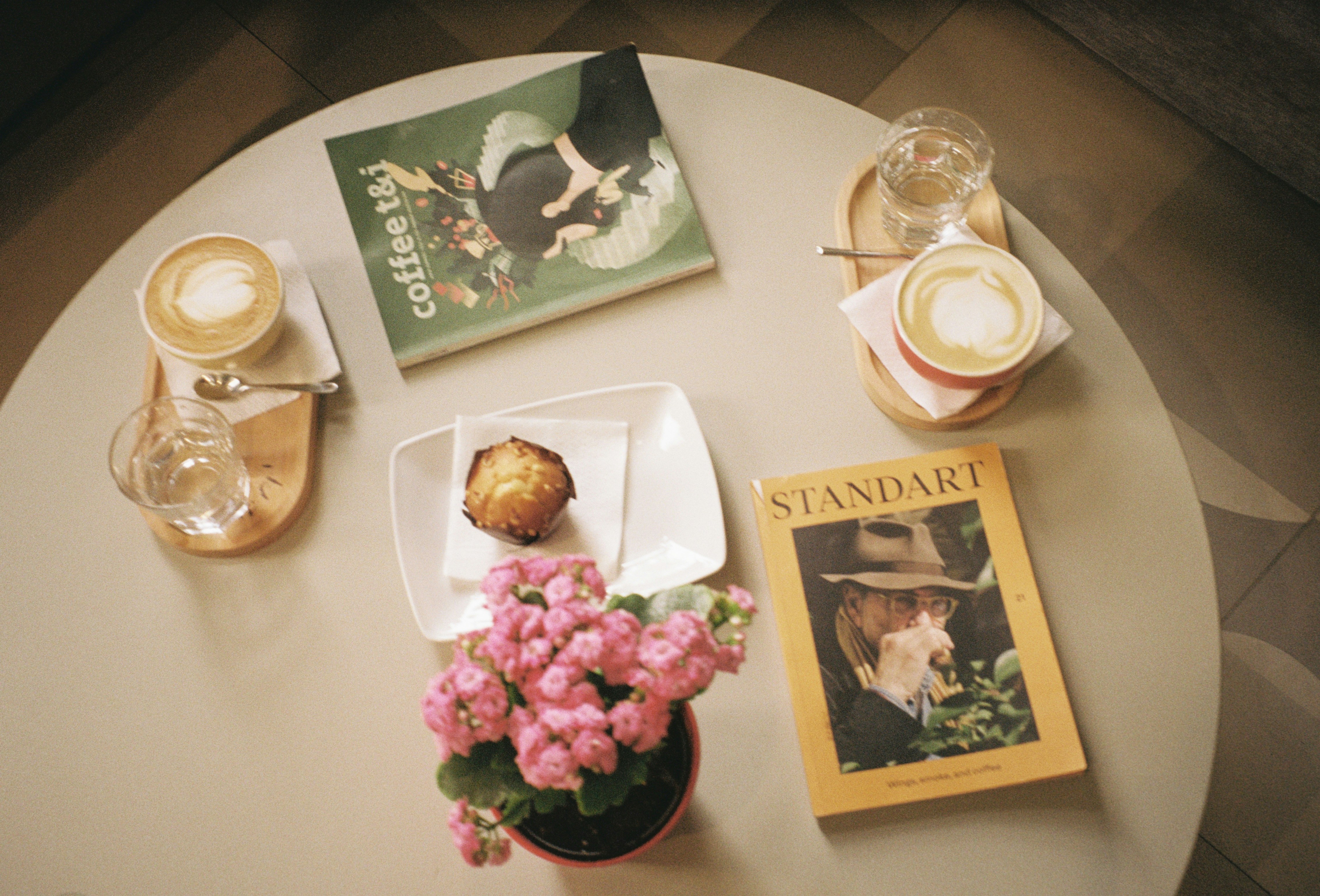 A table topped with a white table top covered in books