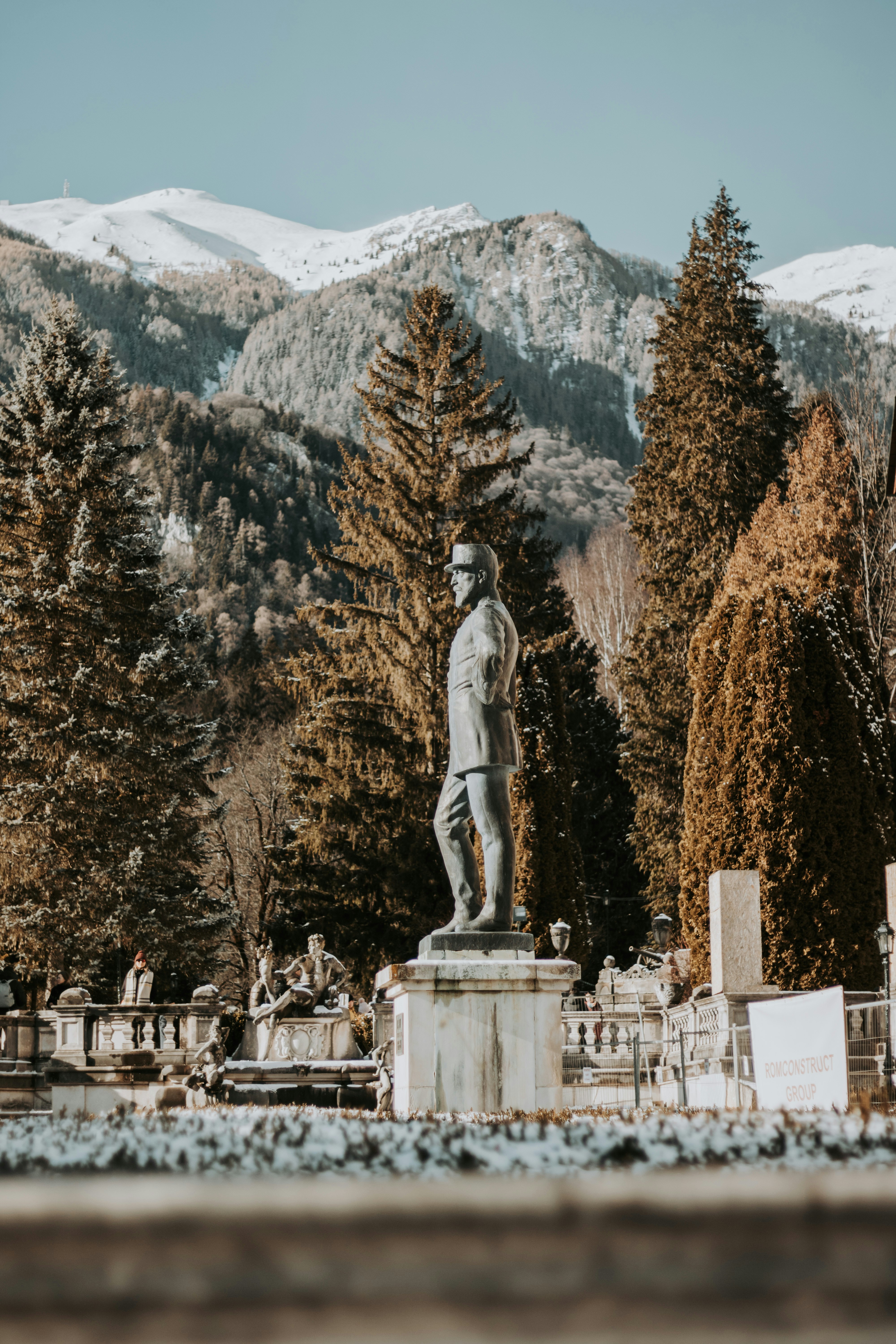 A statue of a man in a cemetery with mountains in the background