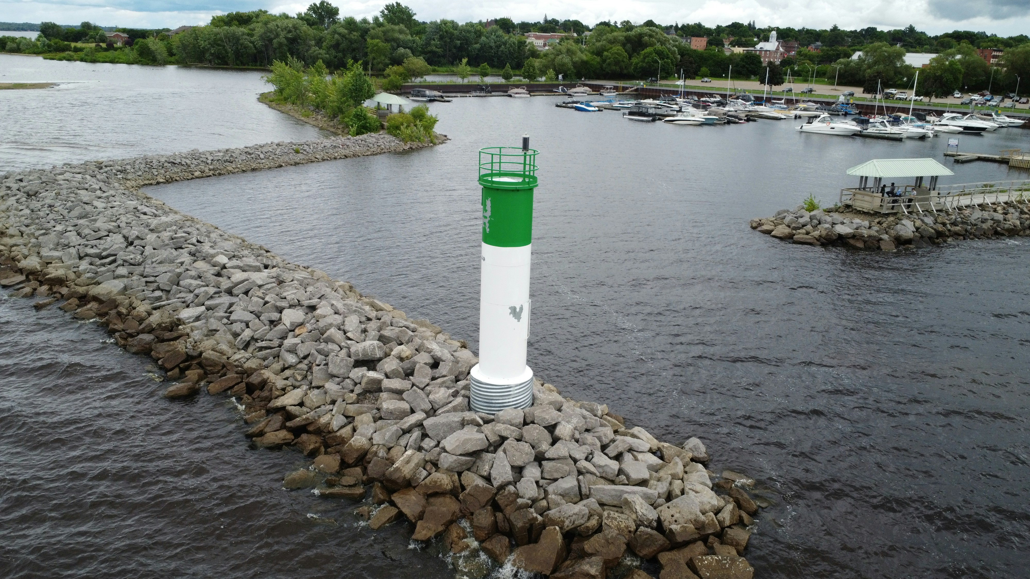 A green and white buoy sitting in the middle of a body of water