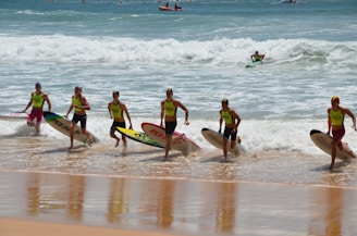 A group of people with surfboards on a beach