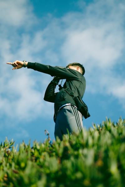 A man standing on top of a lush green hillside