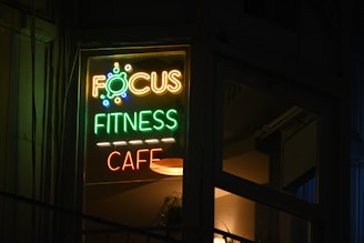 A focus fitness cafe sign lit up at night