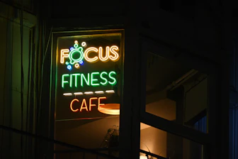 A focus fitness cafe sign lit up at night