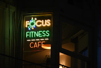 A focus fitness cafe sign lit up at night