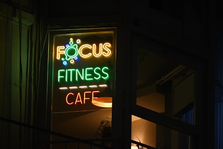 A focus fitness cafe sign lit up at night