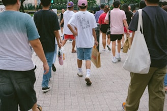A group of people walking down a sidewalk