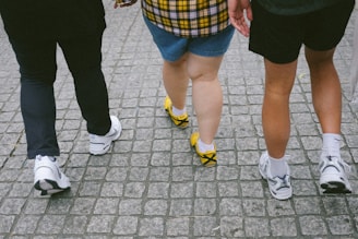 A group of people walking down a sidewalk