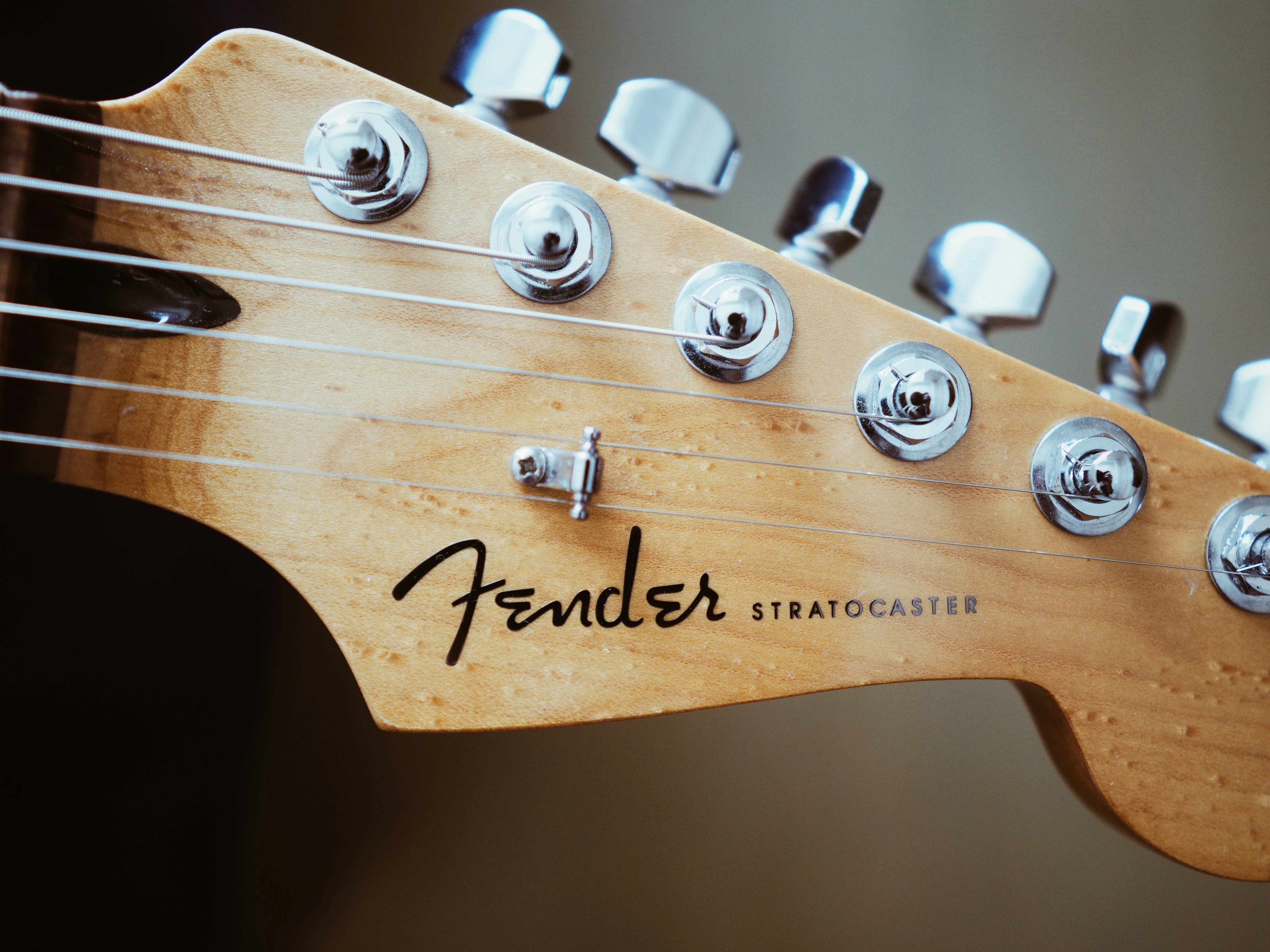 A close up of a guitar's neck with the name fender on it